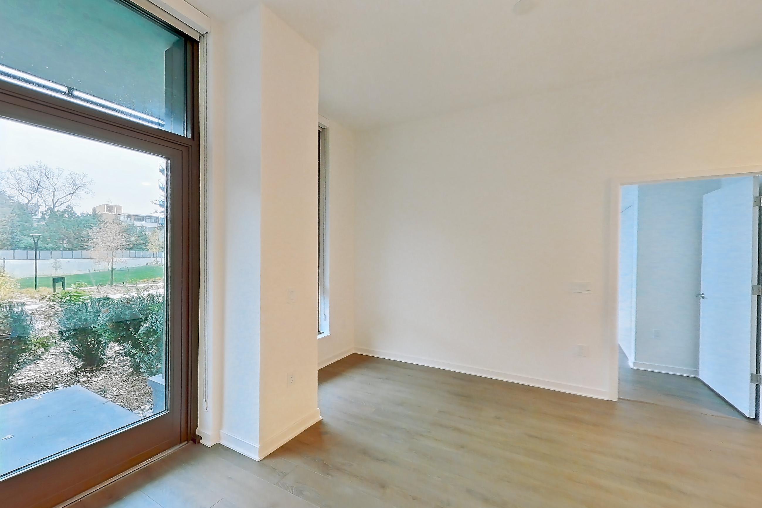 Living room with city view and light wood-finish flooring, Apartment 0120 at Aerie