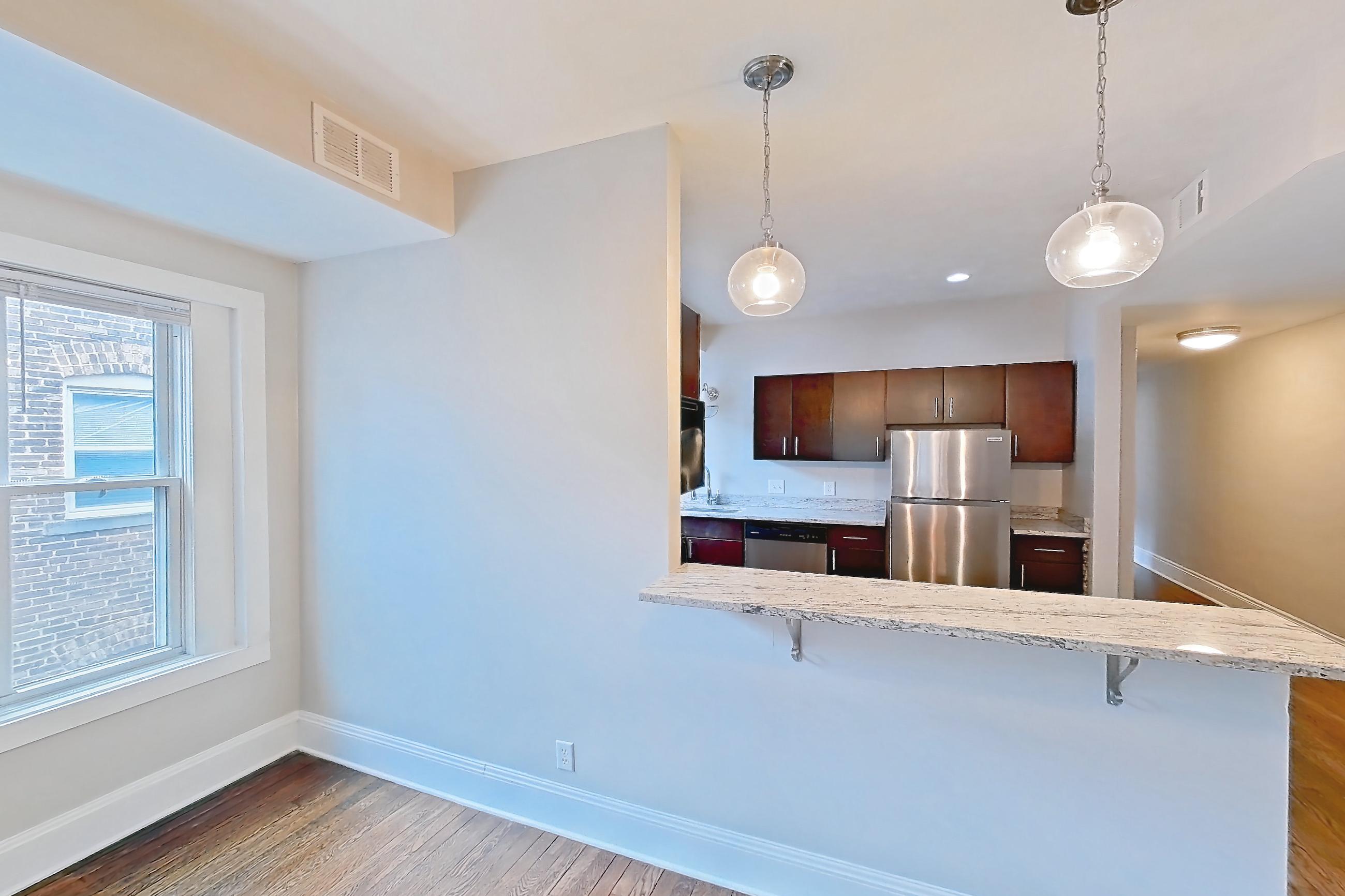 Dining room with dark wood-finish flooring, dishwasher, refrigerator, stainless steel appliances, and wood-finish flooring, Apartment 5 at Integrity Cleveland Heights