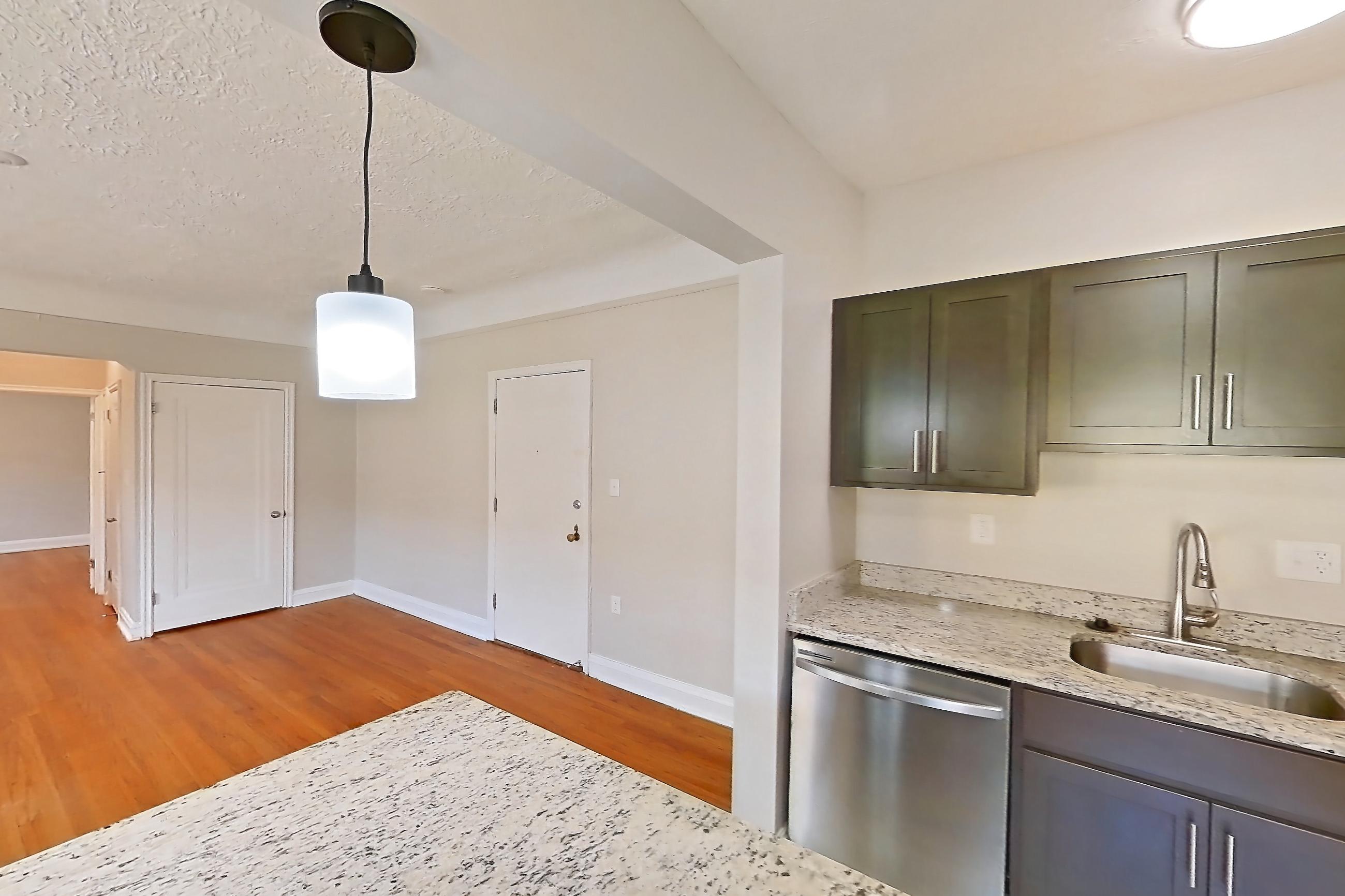 Kitchen with dishwasher, gas range, light stone countertops, light wood-finish flooring, oven/range, stainless steel appliances, and wood-look tile flooring, Apartment 403 at Integrity Gold Coast