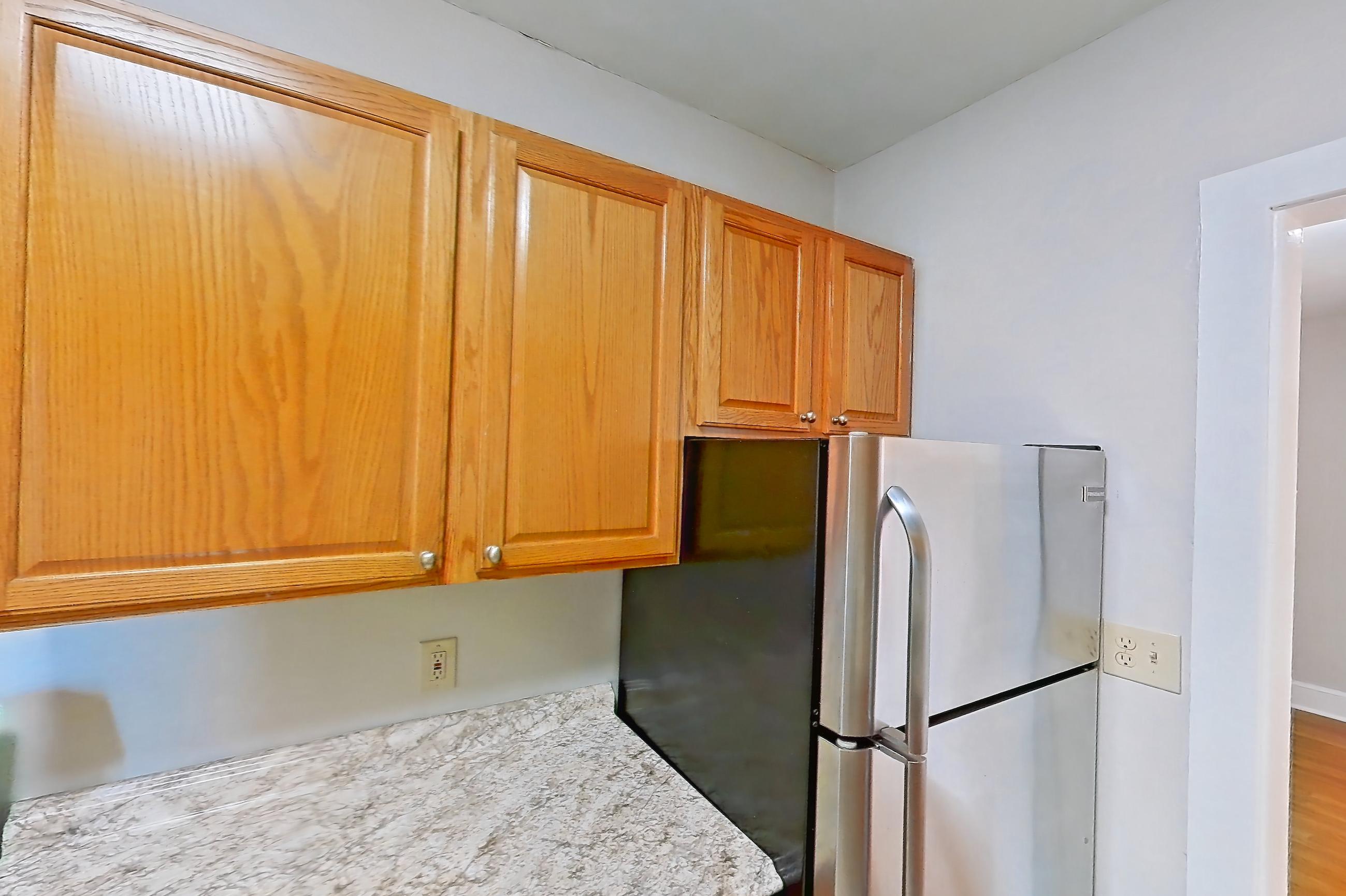 Kitchen with dishwasher, gas range, light countertops, light stone countertops, light tile flooring, oven/range, refrigerator, and stainless steel appliances, Apartment 97-17 at Integrity Gold Coast