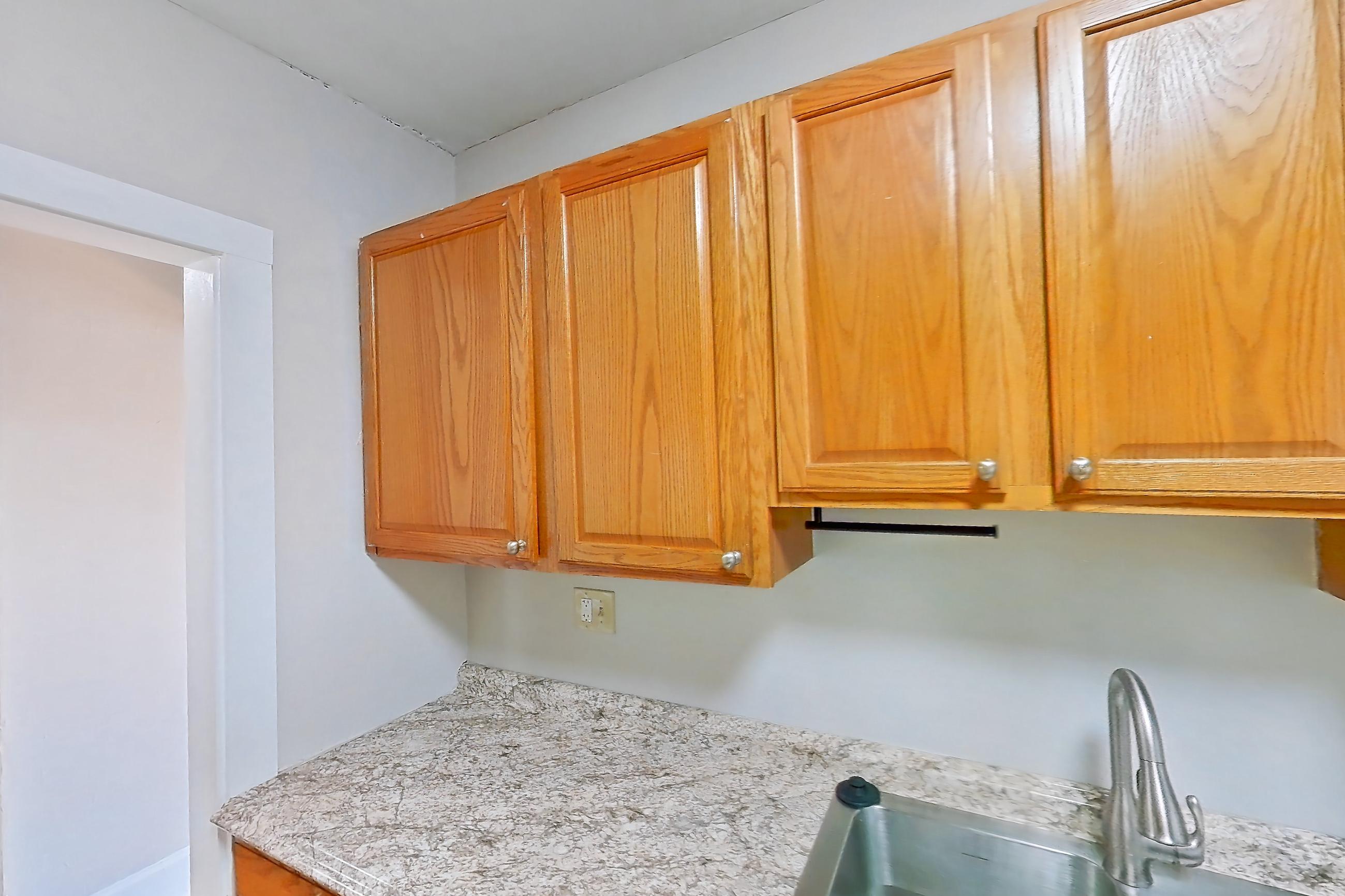 Kitchen with dishwasher, gas range, light countertops, light stone countertops, light tile flooring, oven/range, refrigerator, and stainless steel appliances, Apartment 97-17 at Integrity Gold Coast
