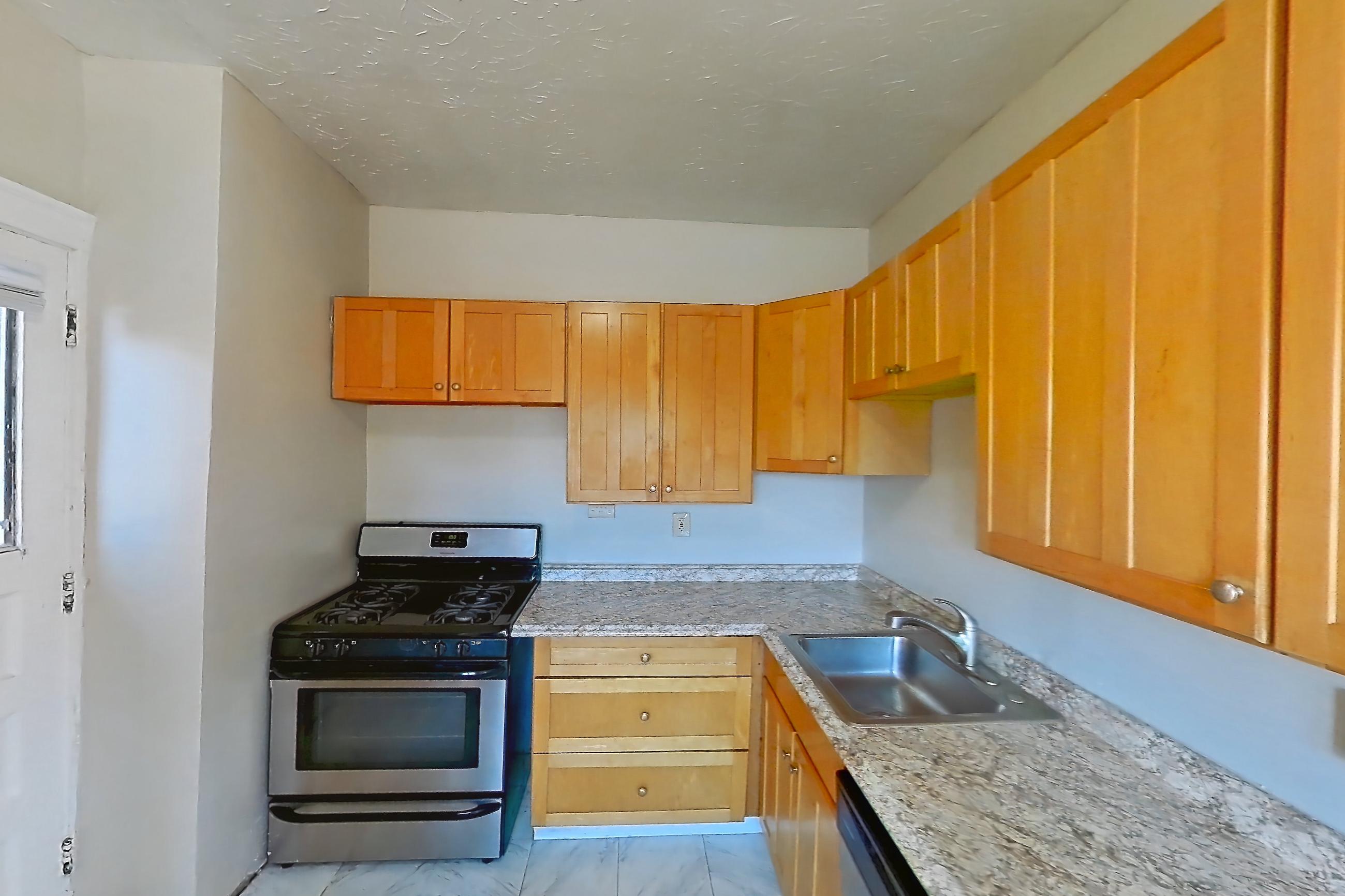 Kitchen with dishwasher, gas range, light countertops, light marble-finish flooring, light stone countertops, marble-look tile flooring, oven/range, refrigerator, and stainless steel appliances, Apartment 95-5 at Integrity Gold Coast