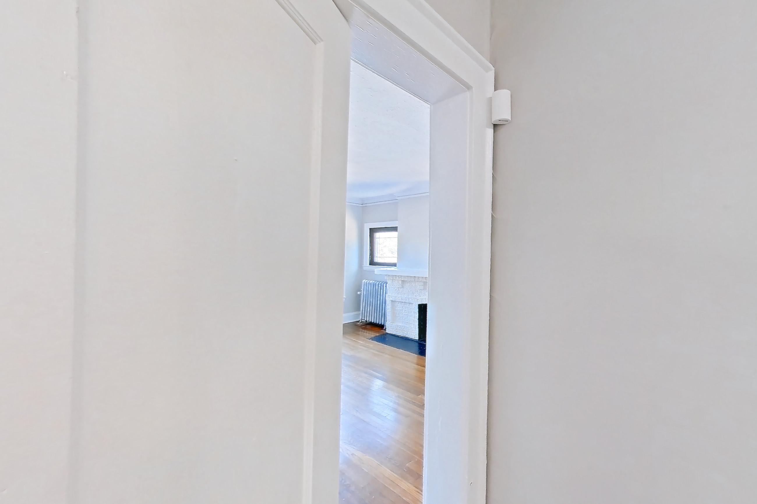 Entryway closet towards living room with dark wood-finish flooring, fireplace, radiator heat, stone fireplace, and wood-finish flooring, Apartment 15-3 at Integrity Gold Coast