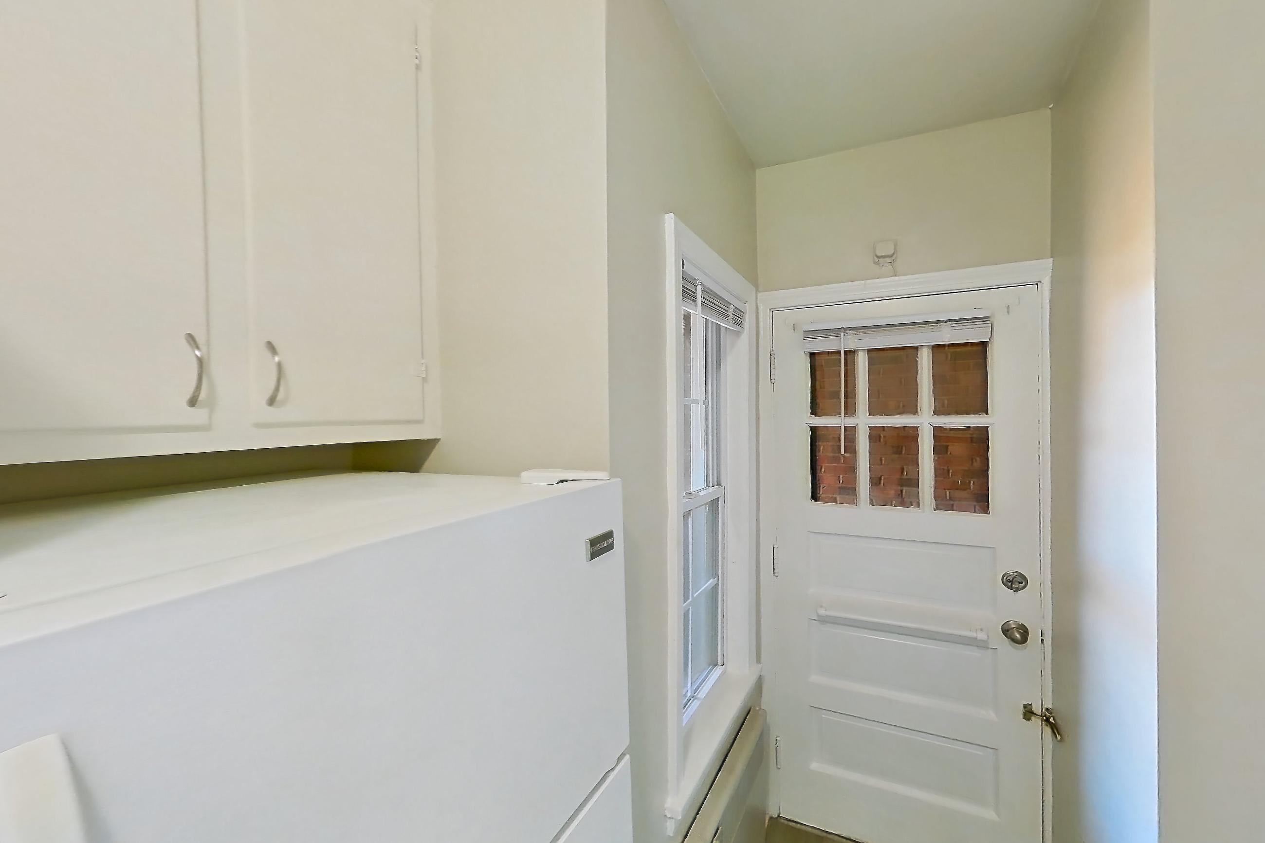 Kitchen with dark countertops, electric range, light wood-finish flooring, oven/range, and white appliances, Apartment 302 at Integrity Gold Coast