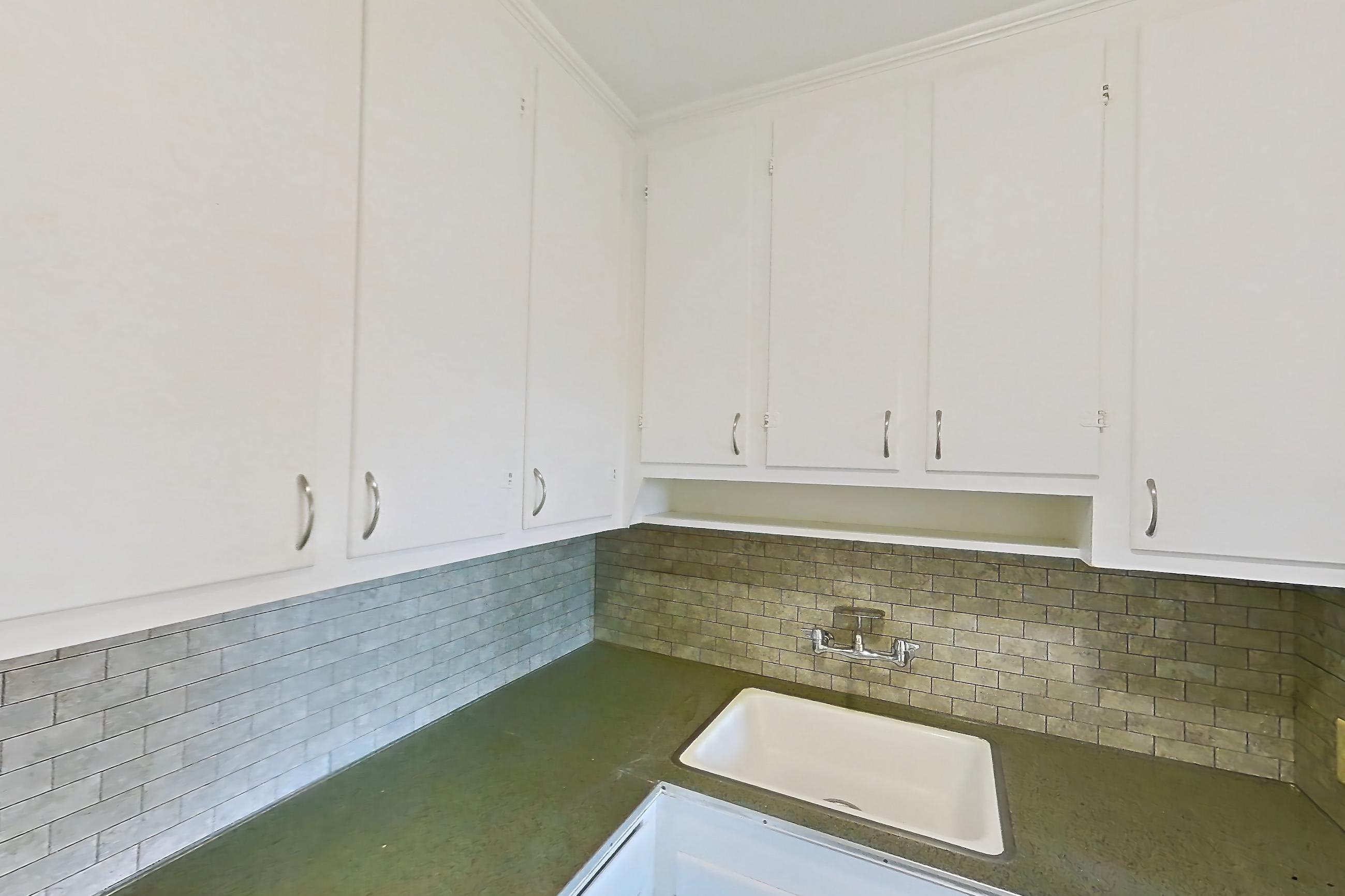 Kitchen with dark countertops, electric range, light wood-finish flooring, oven/range, and white appliances, Apartment 302 at Integrity Gold Coast
