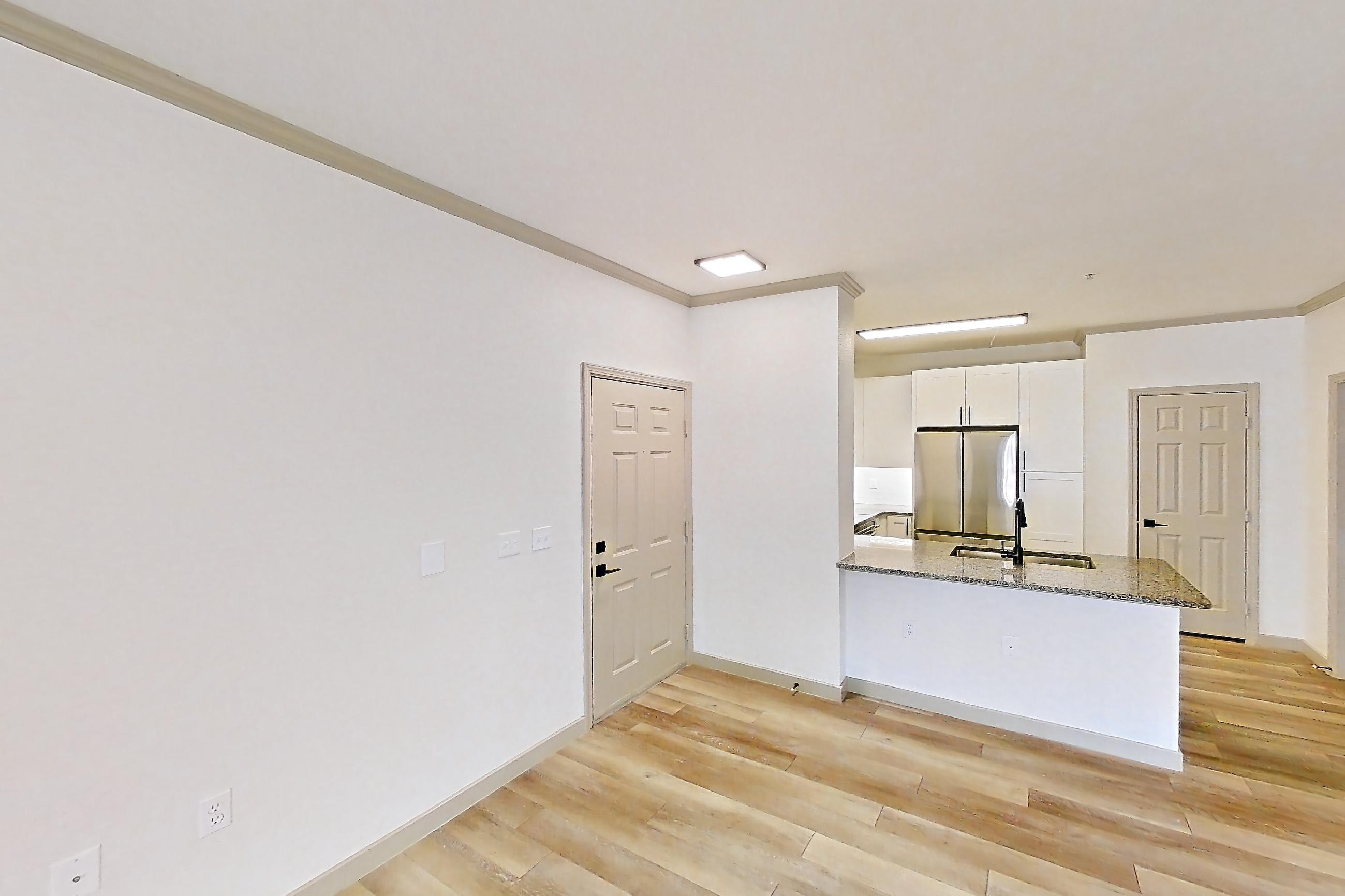 Living space with light wood-finish flooring, refrigerator, and stainless steel appliances, Apartment 10-208 at Cortland Westminster