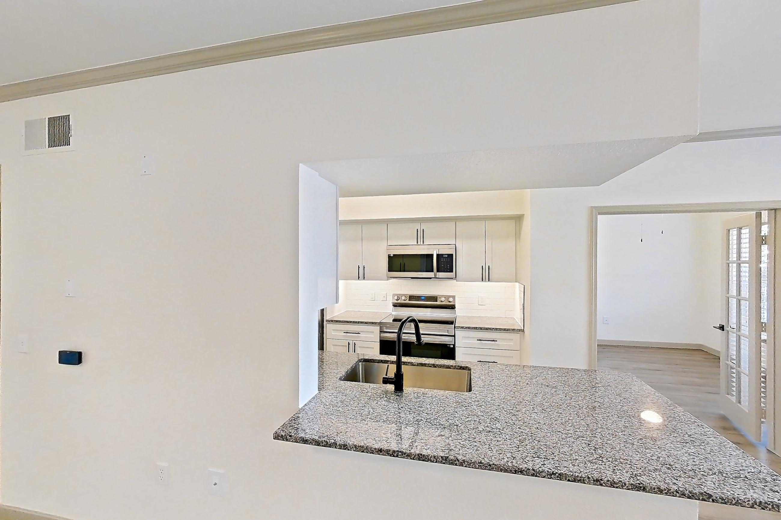 Living space with electric range, light stone countertops, light wood-finish flooring, oven/range, and stainless steel appliances, Apartment 20-106 at Cortland Westminster