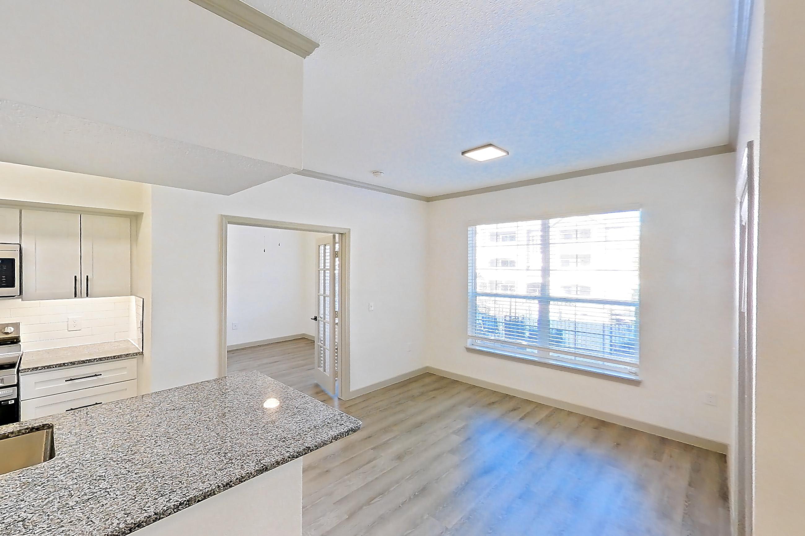 Living space with electric range, light stone countertops, light wood-finish flooring, oven/range, and stainless steel appliances, Apartment 20-106 at Cortland Westminster