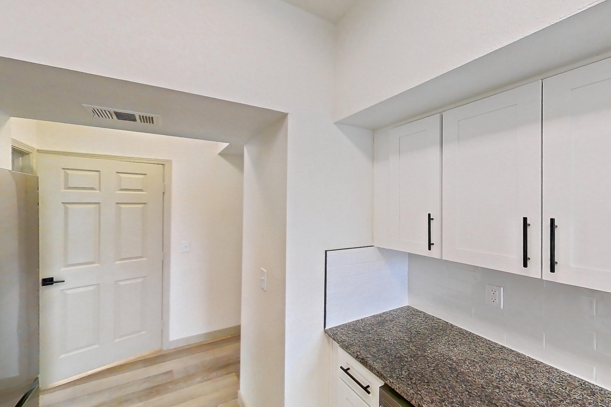 Kitchen with dark stone countertops, dishwasher, electric range, light wood-finish flooring, microwave, oven/range, refrigerator, and stainless steel appliances, Apartment 19-208 at Cortland Westminster