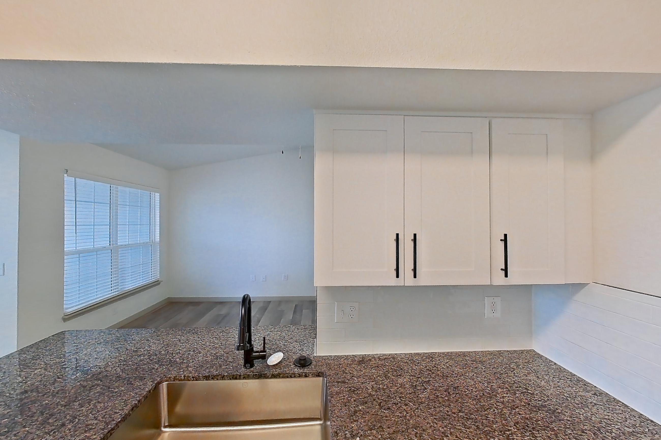 Kitchen with dark stone countertops, dishwasher, electric range, light wood-finish flooring, microwave, oven/range, refrigerator, and stainless steel appliances, Apartment 21-205 at Cortland Westminster