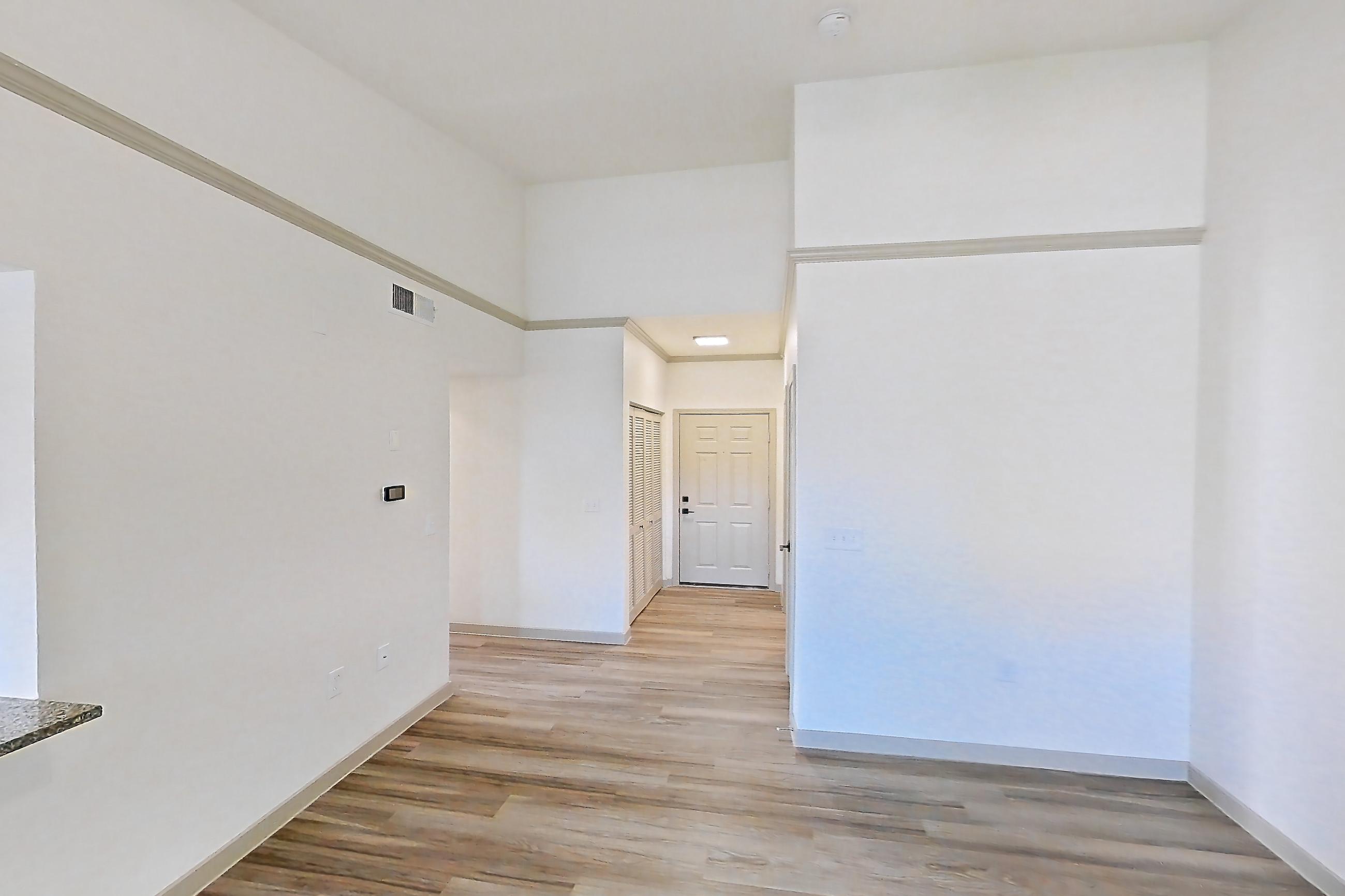 Living space with dark stone countertops, electric range, kitchen island, light wood-finish flooring, oven/range, range hood, refrigerator, and stainless steel appliances, Apartment 22-204 at Cortland Westminster