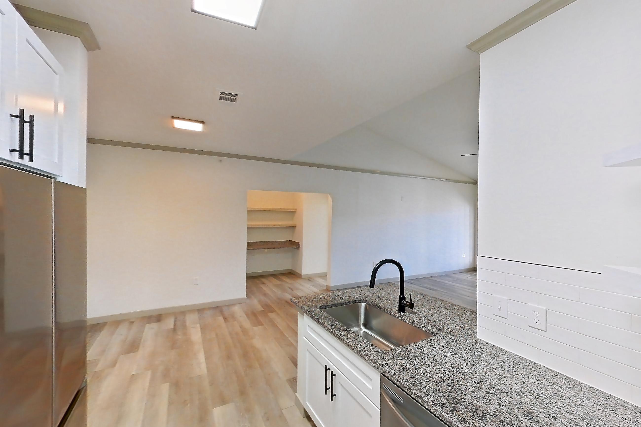 Kitchen with dishwasher, electric range, light countertops, light stone countertops, light wood-finish flooring, microwave, oven/range, refrigerator, and stainless steel appliances, Apartment 04-302 at Cortland Westminster