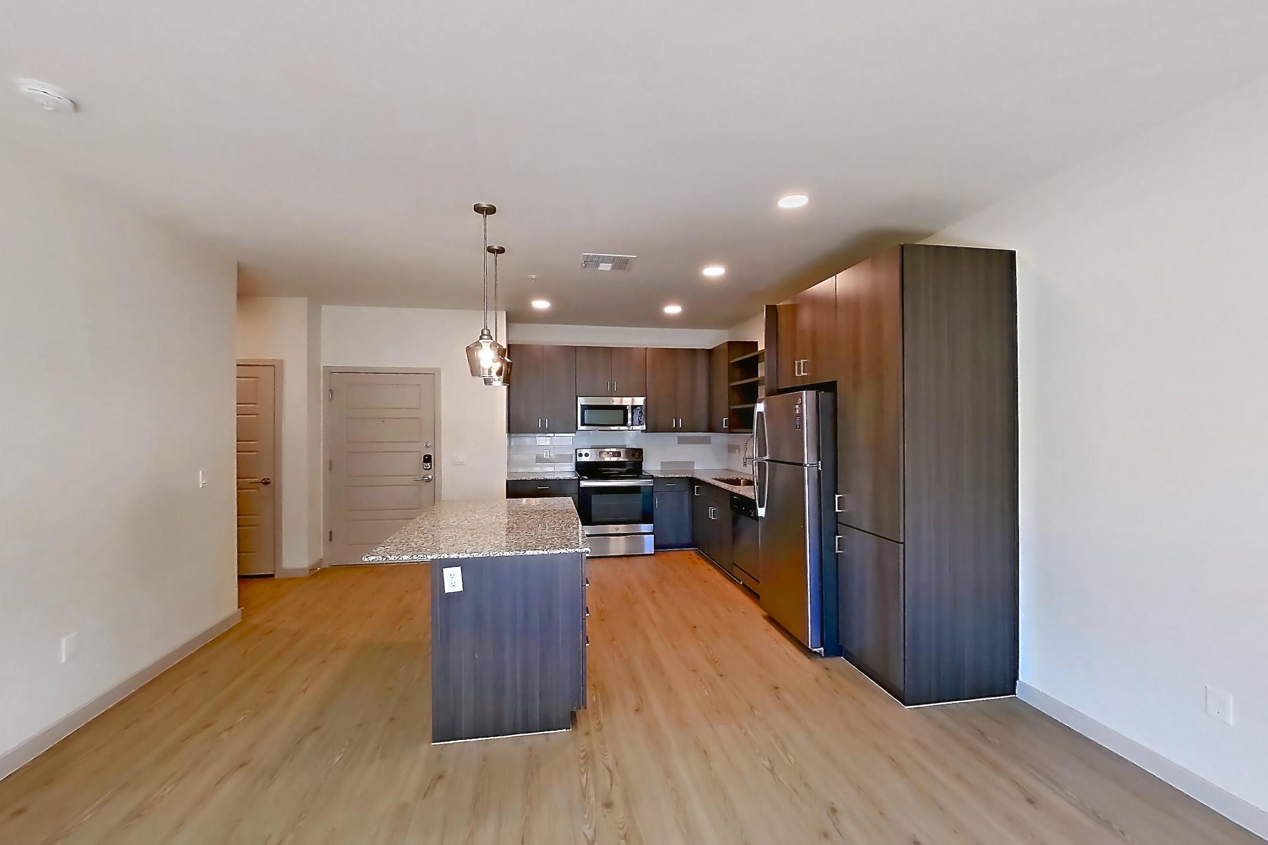 Living room with dishwasher, electric range, light countertops, light stone countertops, light wood-finish flooring, oven/range, refrigerator, and stainless steel appliances, Apartment 1015 at Cortland at P83