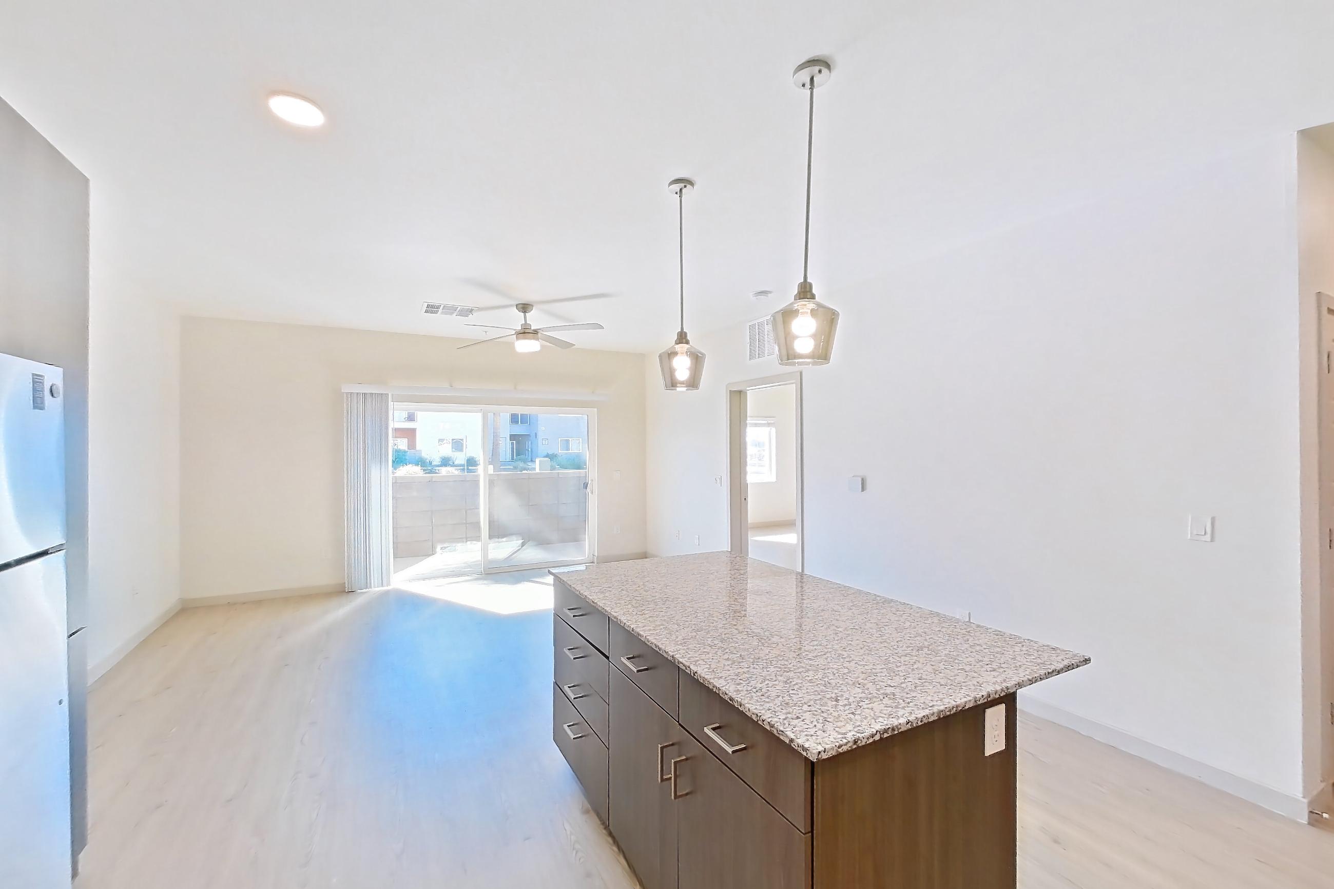 Kitchen with dishwasher, electric range, light stone countertops, light wood-finish flooring, oven/range, refrigerator, and stainless steel appliances, Apartment 1140 at Cortland at P83