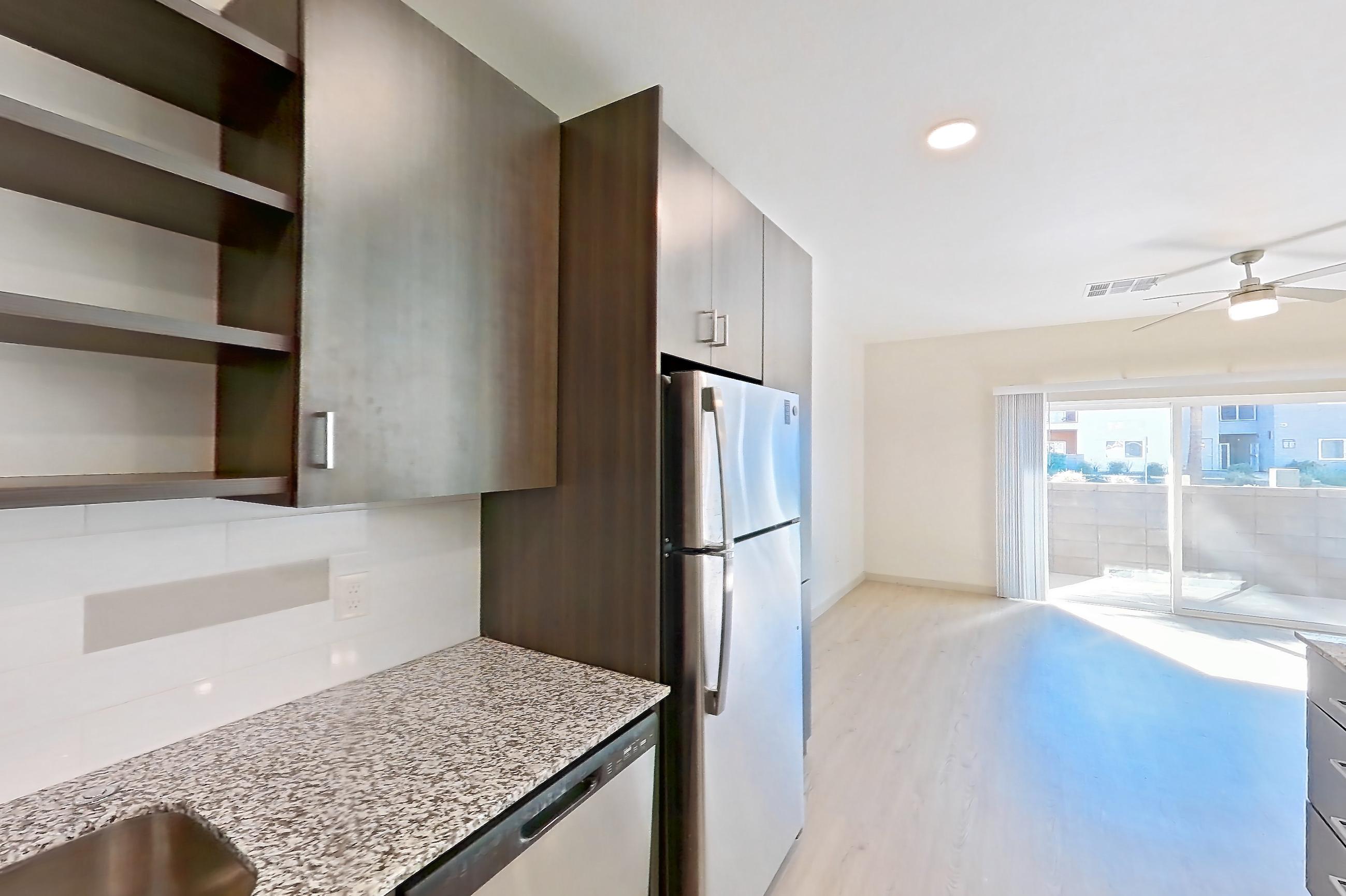 Kitchen with dishwasher, electric range, light stone countertops, light wood-finish flooring, oven/range, refrigerator, and stainless steel appliances, Apartment 1140 at Cortland at P83