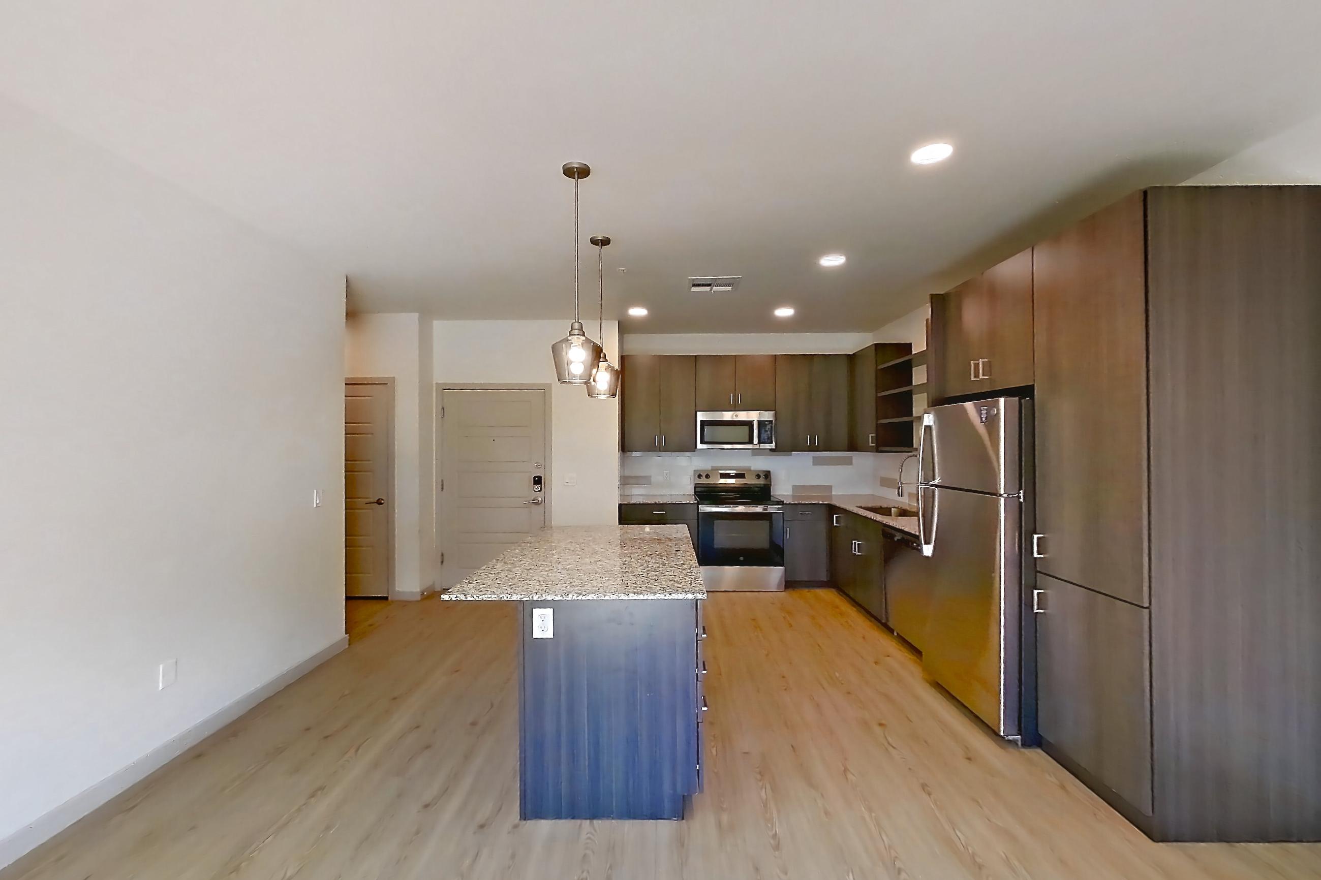 Living room with electric range, light countertops, light stone countertops, light wood-finish flooring, oven/range, refrigerator, and stainless steel appliances, Apartment 1140 at Cortland at P83