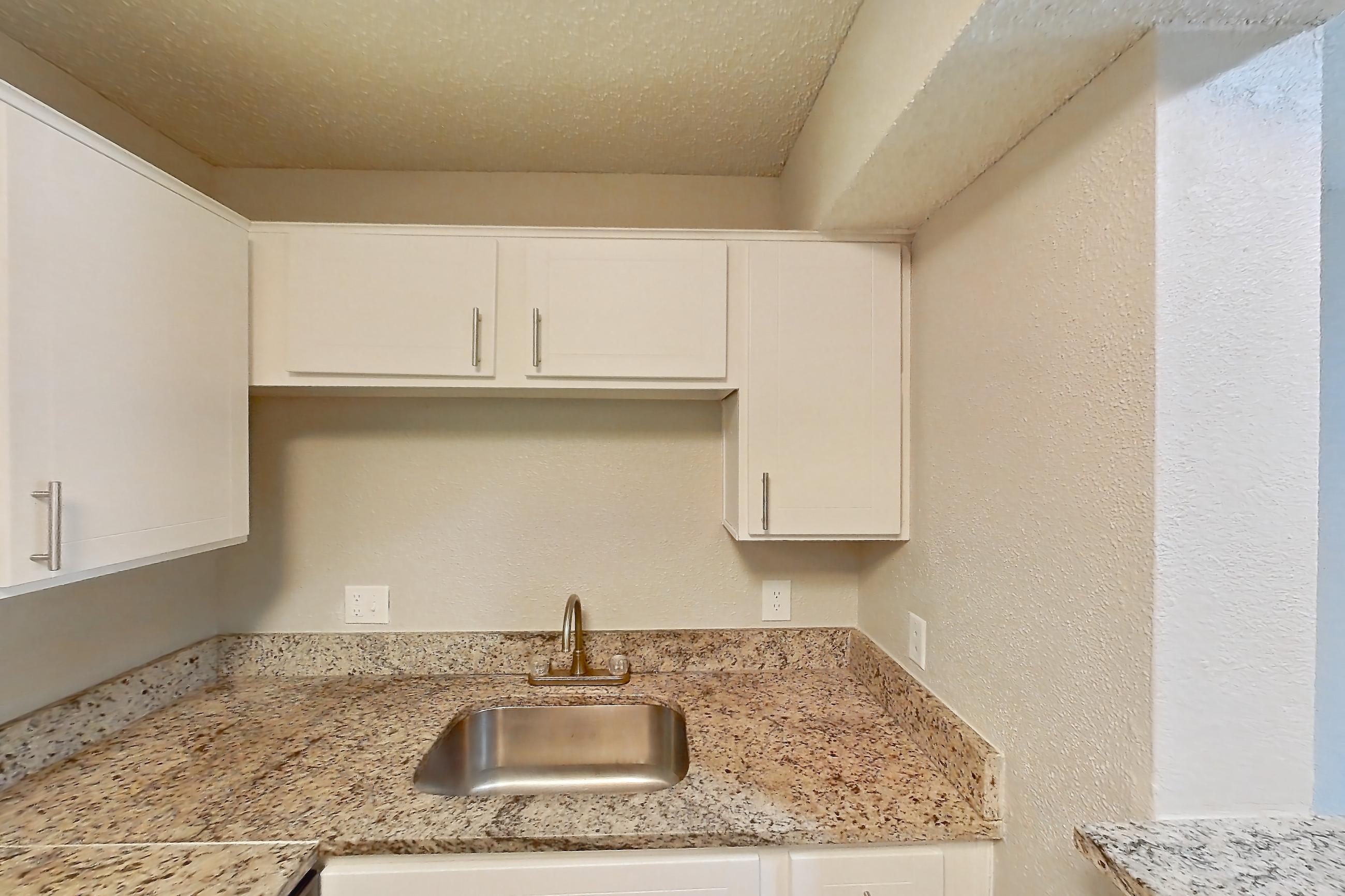 Kitchen with dishwasher, electric range, light countertops, light stone countertops, light wood-finish flooring, oven/range, and stainless steel appliances, Apartment 2103 at Cortland at the Hammocks