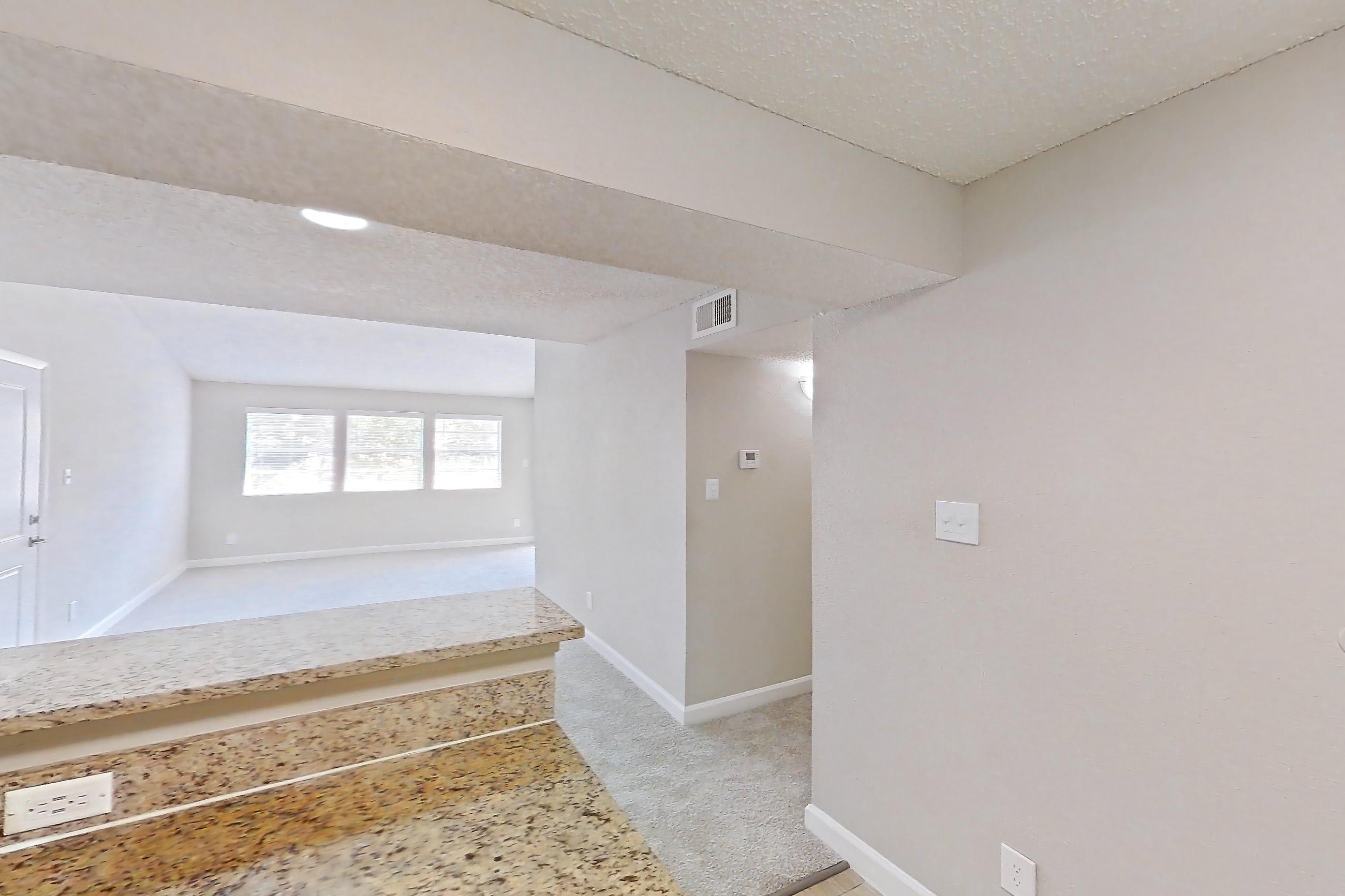 Kitchen with dishwasher, electric range, light carpet, light stone countertops, light wood-finish flooring, oven/range, range hood, refrigerator, and stainless steel appliances, Apartment 0506 at Cortland at the Hammocks