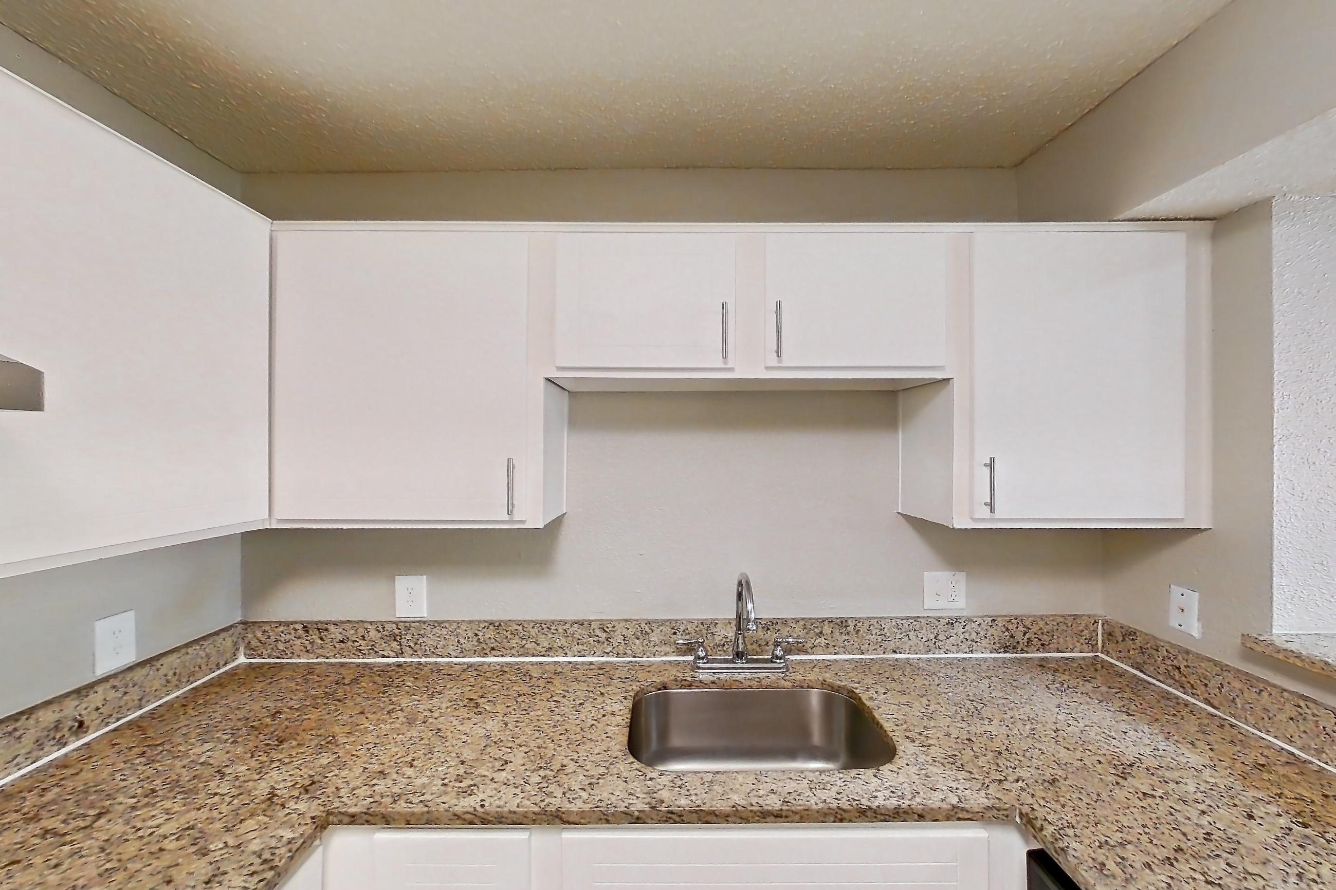 Kitchen with dishwasher, electric range, light carpet, light stone countertops, light wood-finish flooring, oven/range, range hood, refrigerator, and stainless steel appliances, Apartment 0506 at Cortland at the Hammocks
