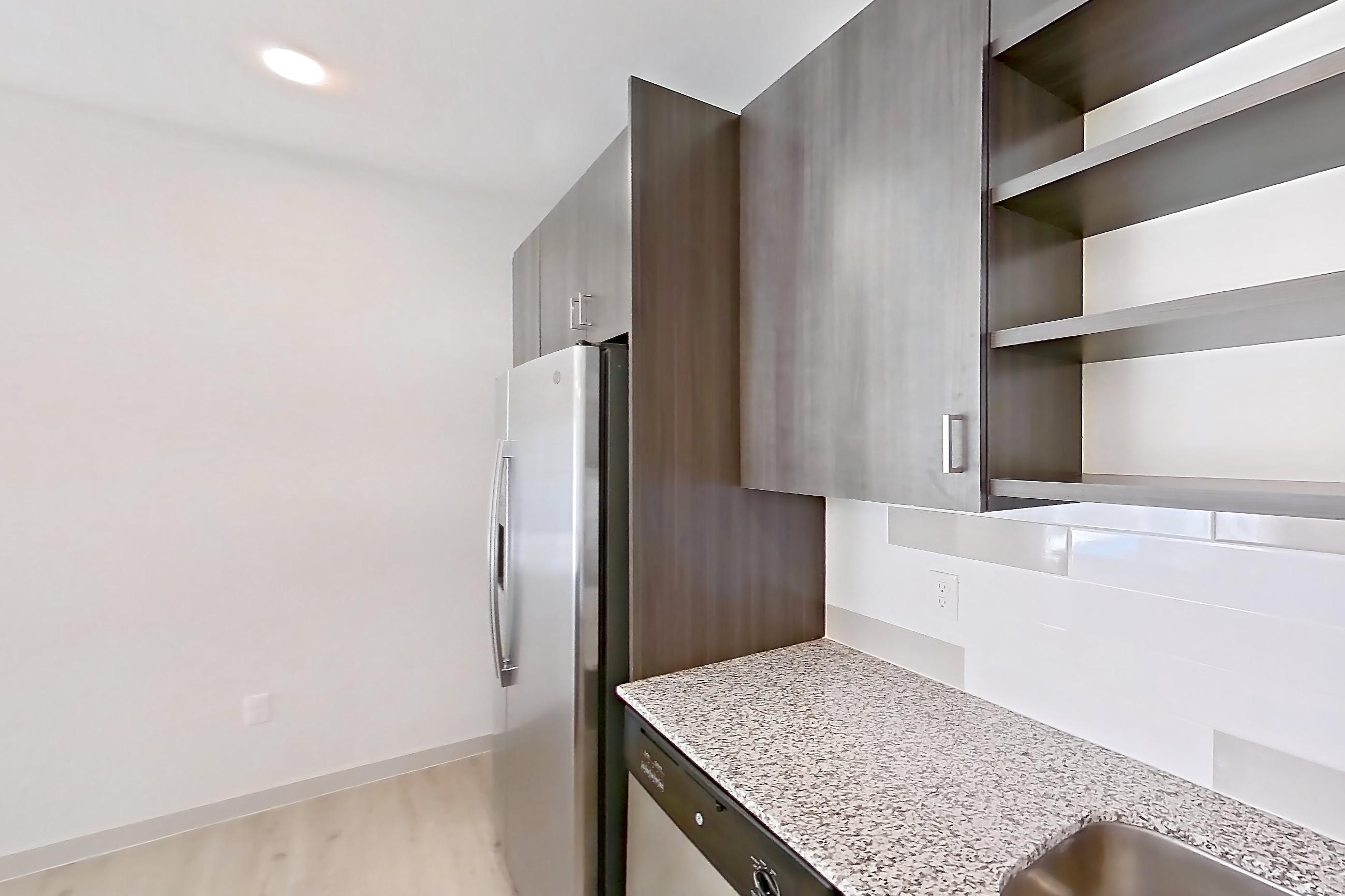 Kitchen with dishwasher, electric range, light stone countertops, light wood-finish flooring, oven/range, refrigerator, stainless steel appliances, and white appliances, Apartment 1097 at Cortland at P83
