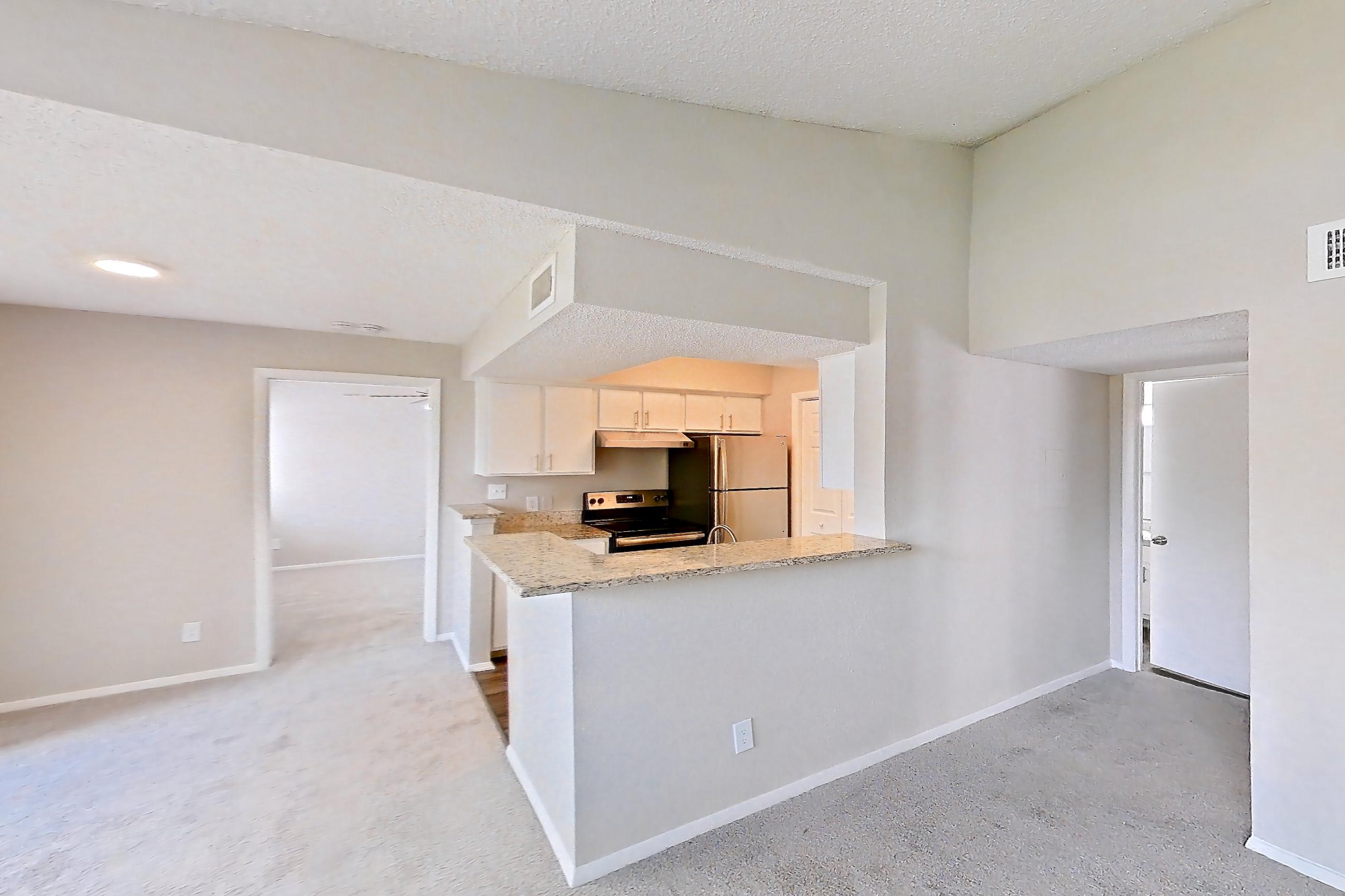 Living room with electric range, light stone countertops, oven/range, refrigerator, and stainless steel appliances, Apartment 1710 at Cortland at the Hammocks