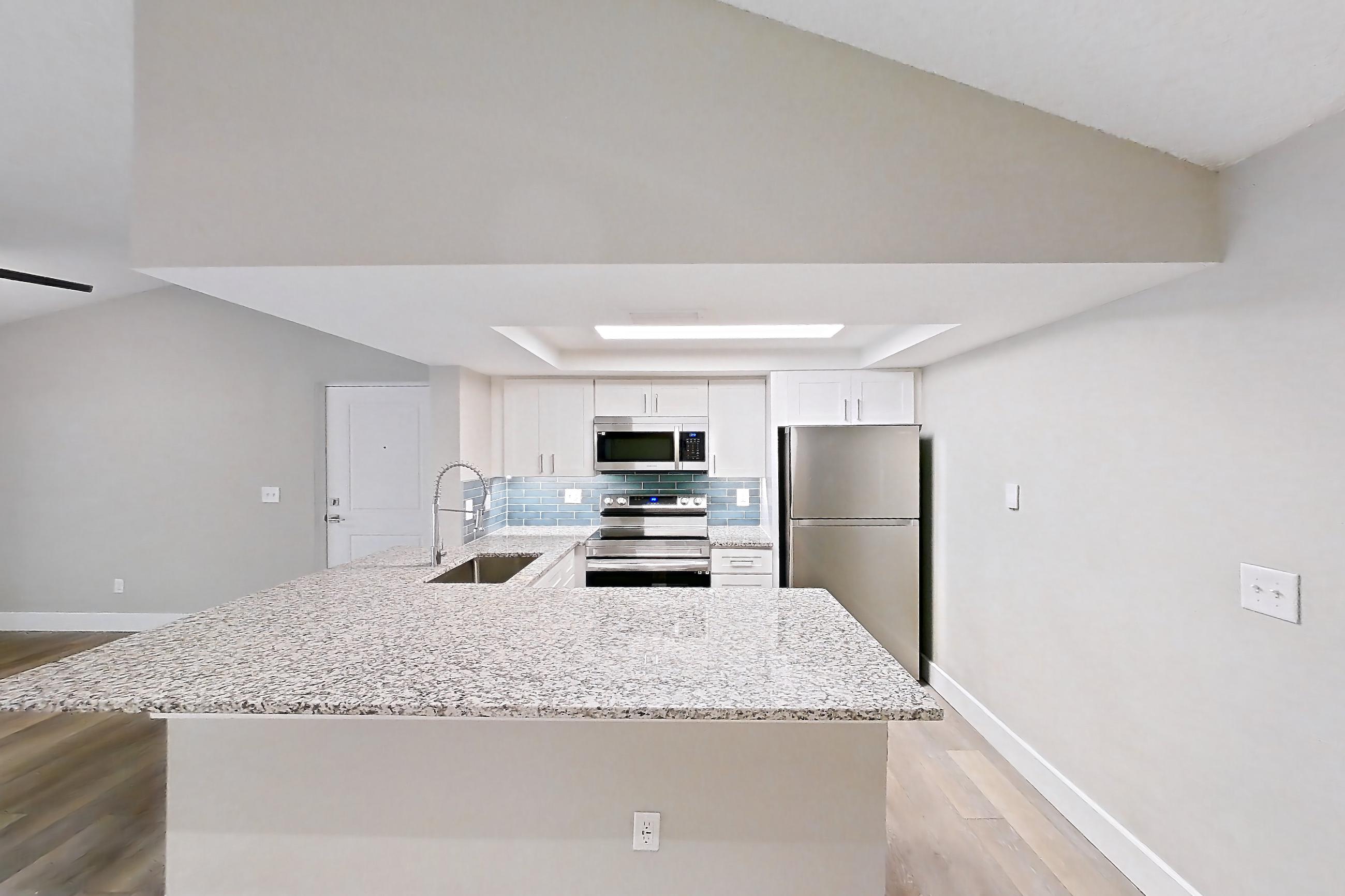 Living space with electric range, light stone countertops, light wood-finish flooring, oven/range, refrigerator, stainless steel appliances, and white appliances, Apartment 02-037 at Cortland at the Hammocks