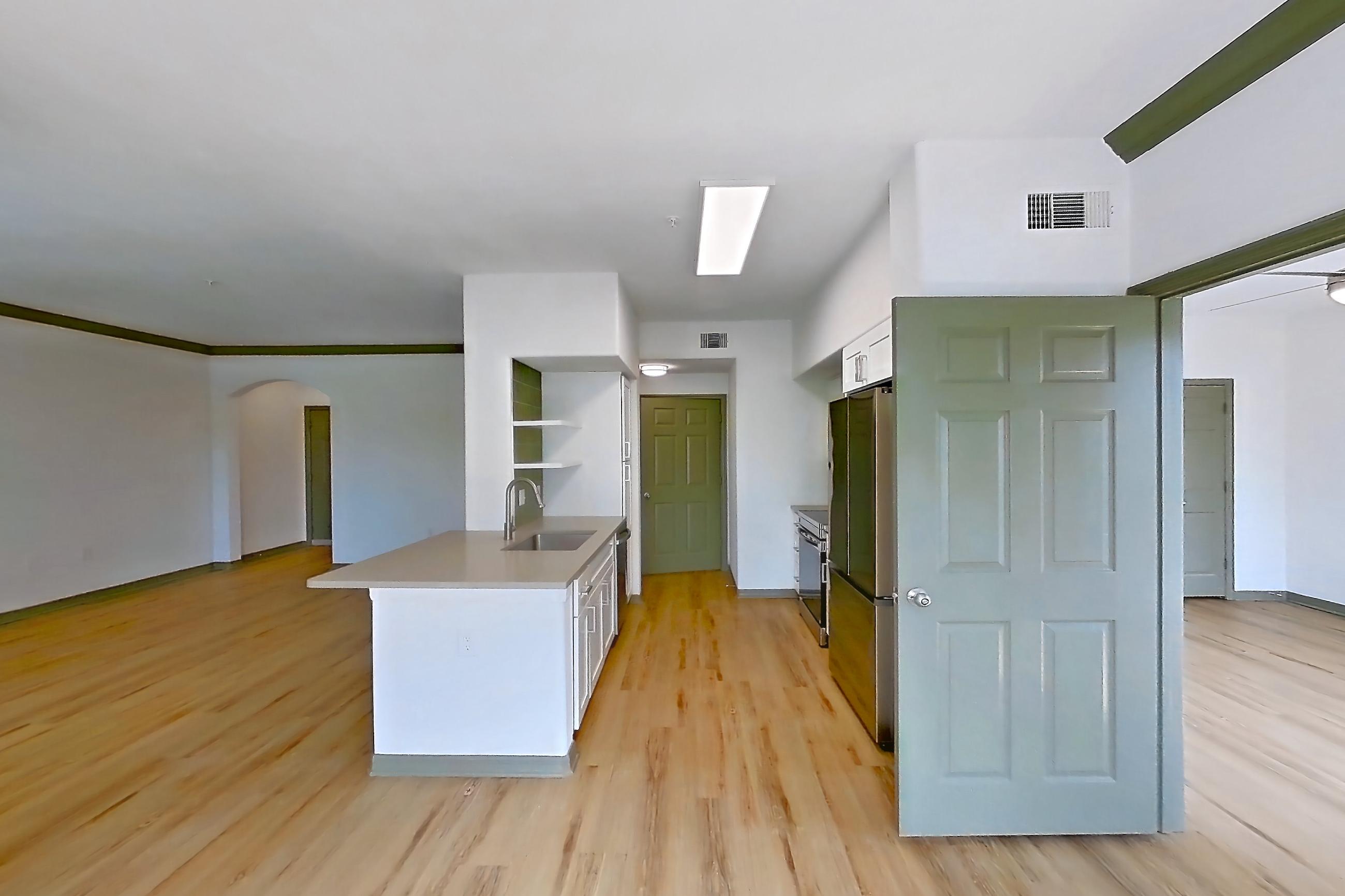 Dining room with electric range, kitchen island, light stone countertops, light wood-finish flooring, oven/range, refrigerator, and stainless steel appliances, Apartment 12309 at Cortland Lakecrest