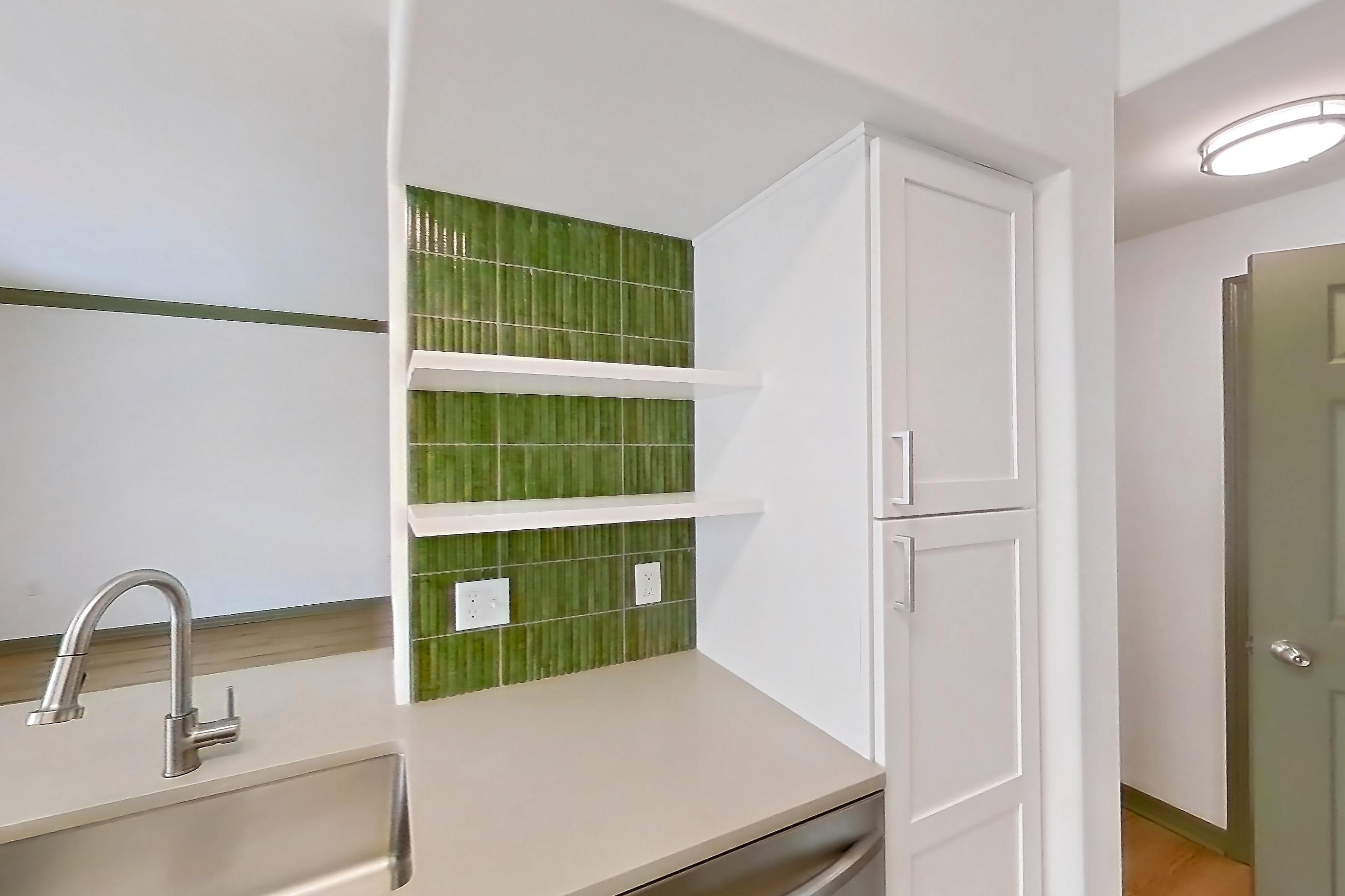 Kitchen with dishwasher, electric range, light countertops, light stone countertops, light wood-finish flooring, microwave, oven/range, refrigerator, and stainless steel appliances, Apartment 12309 at Cortland Lakecrest