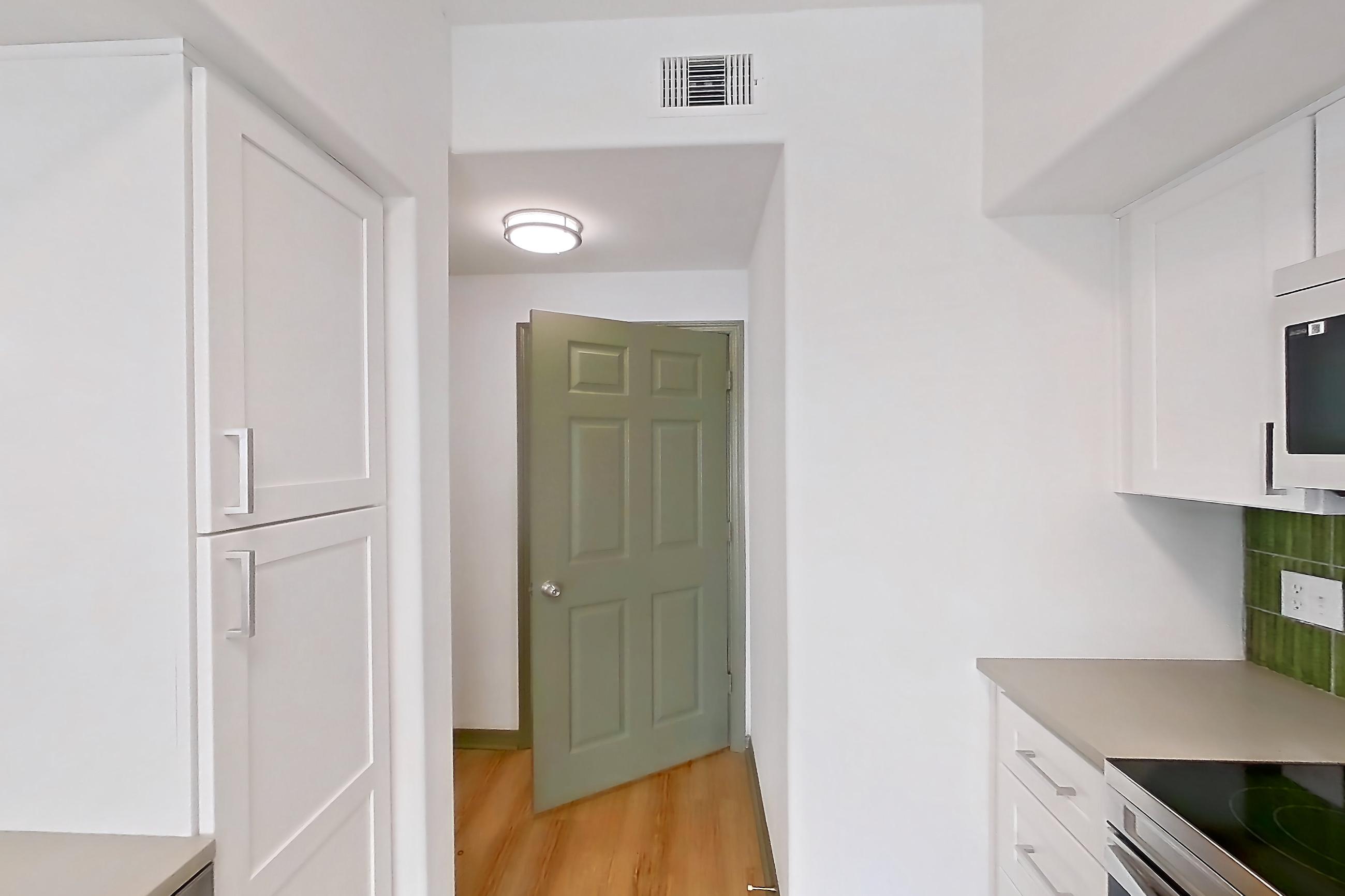 Kitchen with dishwasher, electric range, light countertops, light stone countertops, light wood-finish flooring, microwave, oven/range, refrigerator, and stainless steel appliances, Apartment 12309 at Cortland Lakecrest