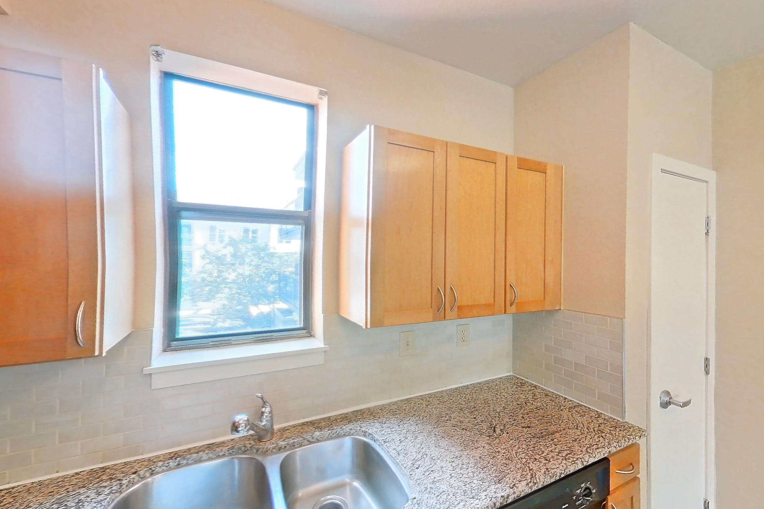 Kitchen with black appliances, dark wood-finish flooring, dishwasher, electric range, light stone countertops, microwave, oven/range, and refrigerator, Apartment A-464-2A at Cortland Belmar