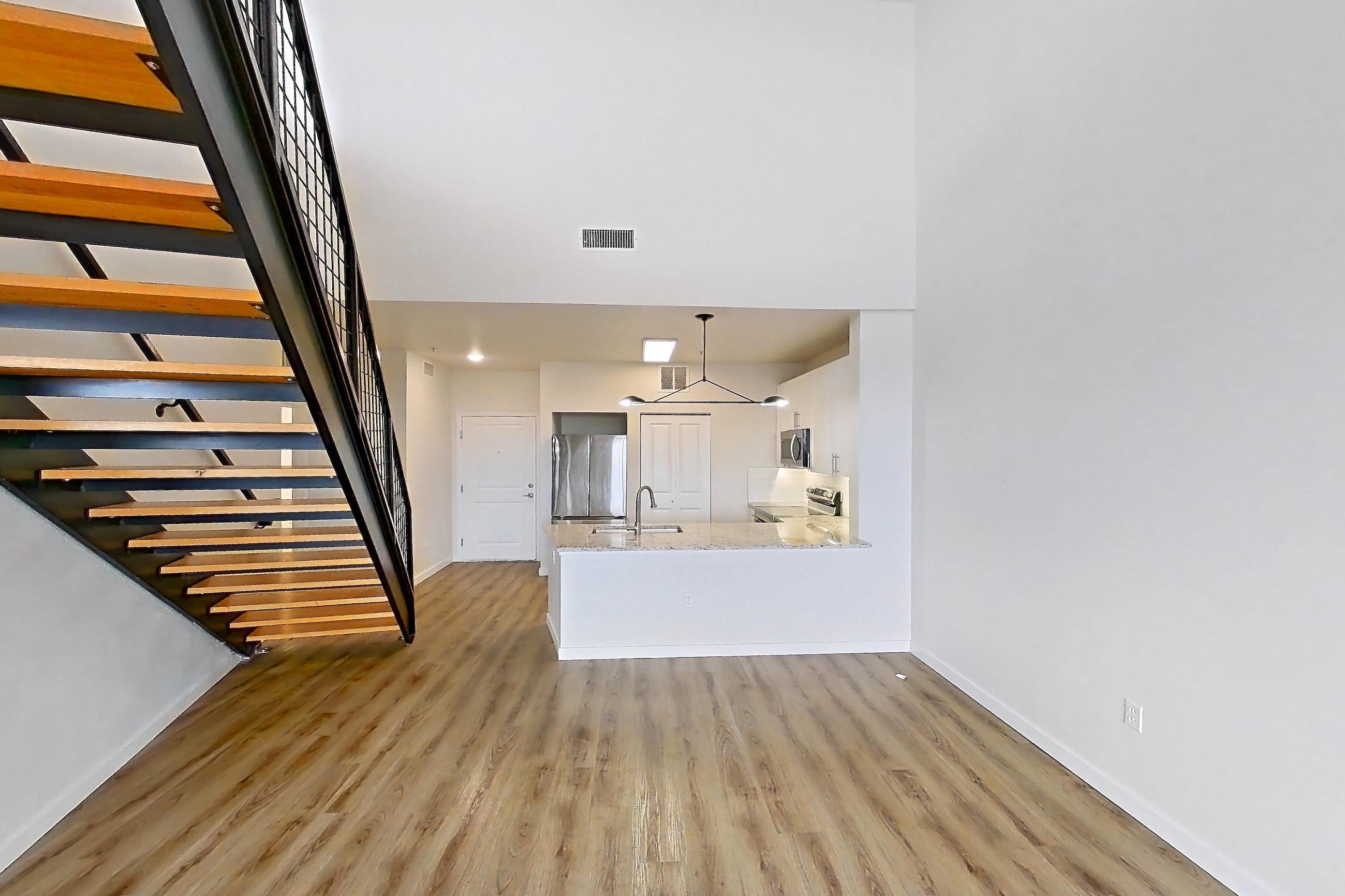 Living space with light wood-finish flooring, oven/range, and stainless steel appliances, Apartment C-424 at Cortland Belmar