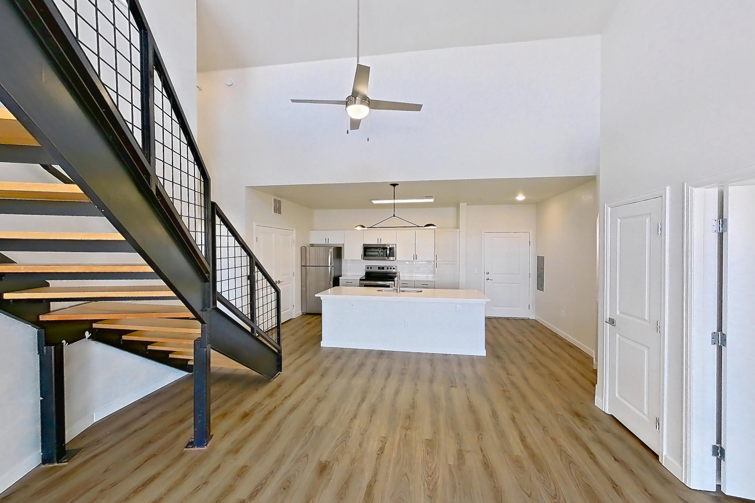 Living space with electric range, kitchen island, light countertops, light wood-finish flooring, oven/range, and stainless steel appliances, Apartment C-440 at Cortland Belmar