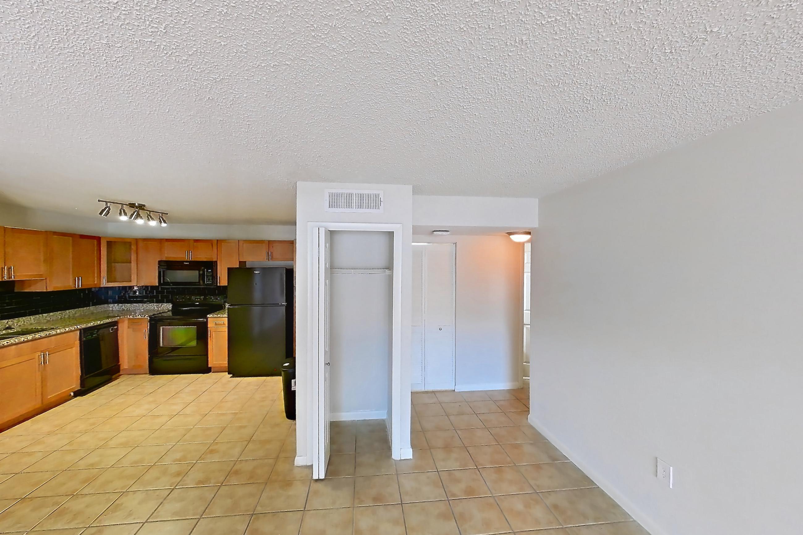 Living space with black appliances, dishwasher, electric range, light stone countertops, light tile flooring, oven/range, and refrigerator, Apartment 185771 at Cortland Bayport
