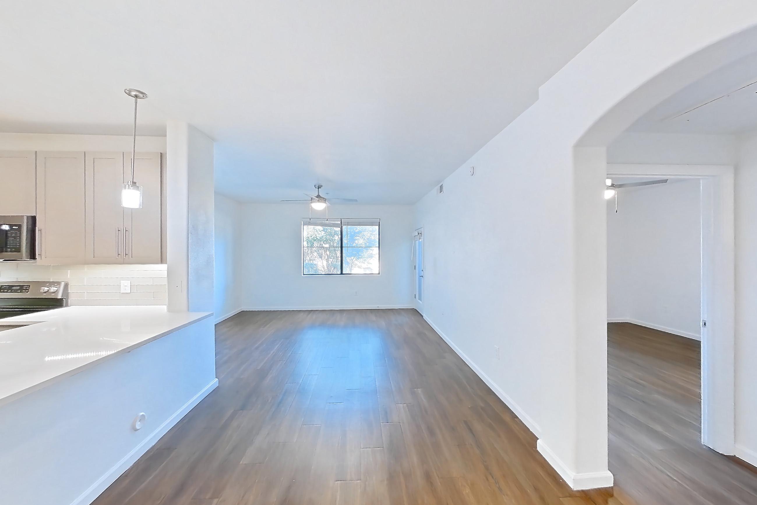 Dining room with dark wood-finish flooring, electric range, light countertops, light wood-finish flooring, oven/range, refrigerator, and stainless steel appliances, Apartment 1066 at Cortland South Mountain