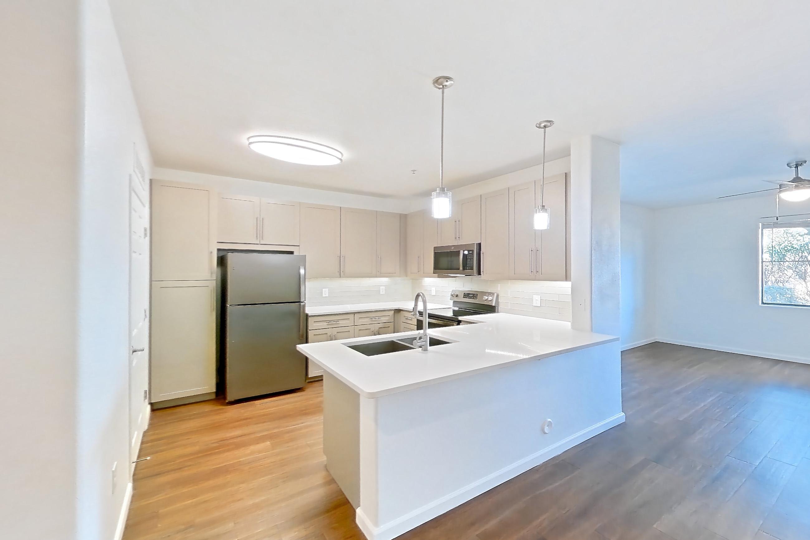Dining room with dark wood-finish flooring, electric range, light countertops, light wood-finish flooring, oven/range, refrigerator, and stainless steel appliances, Apartment 1066 at Cortland South Mountain