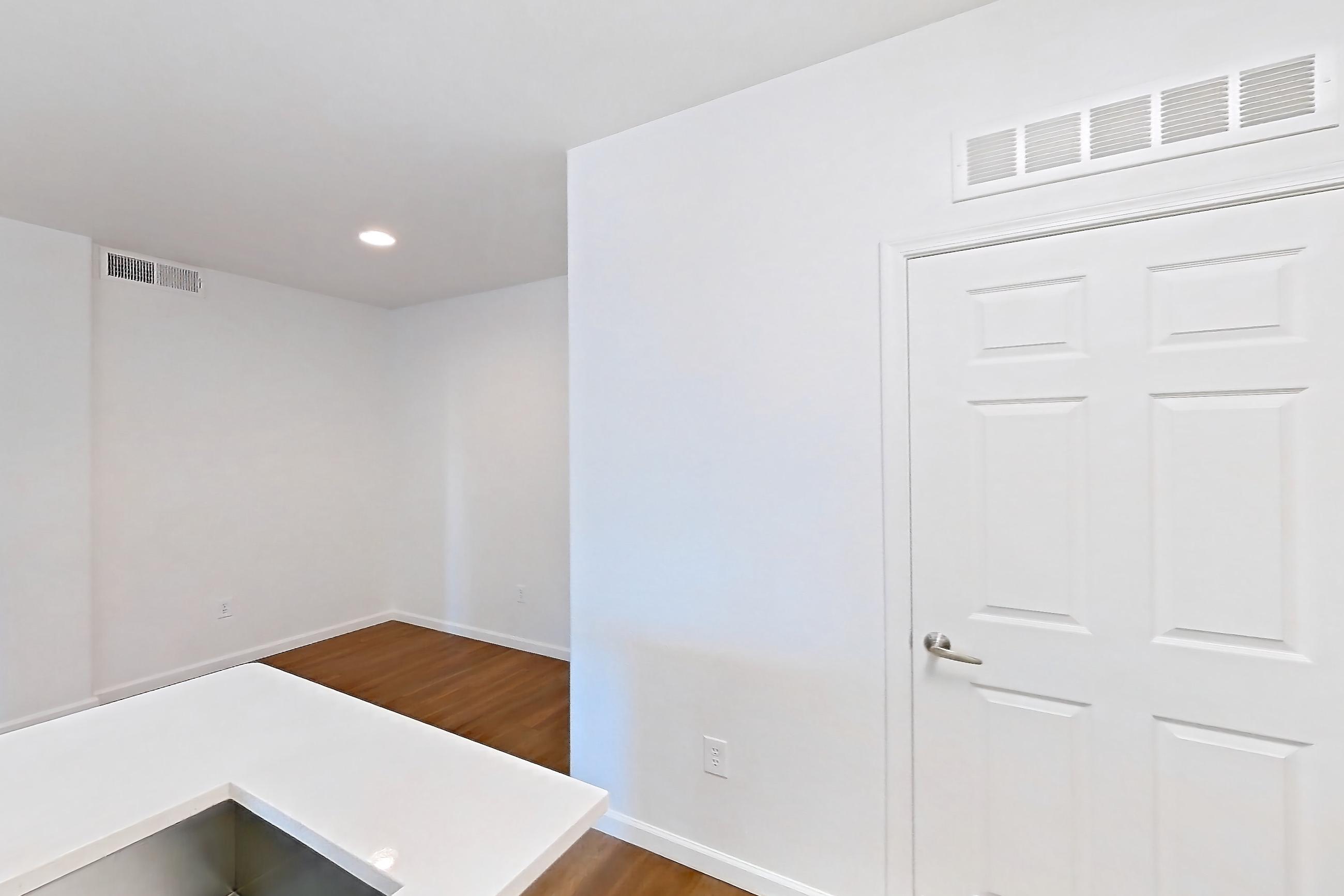Kitchen with electric range, kitchen island, light countertops, light wood-finish flooring, microwave, oven/range, refrigerator, and stainless steel appliances, Apartment 1066 at Cortland South Mountain
