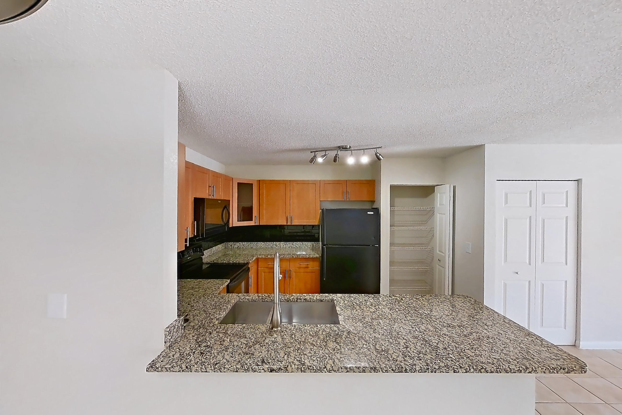 Dining room with black appliances, dark stone countertops, electric range, light countertops, light tile flooring, microwave, oven/range, and refrigerator, Apartment 065574 at Cortland Bayport