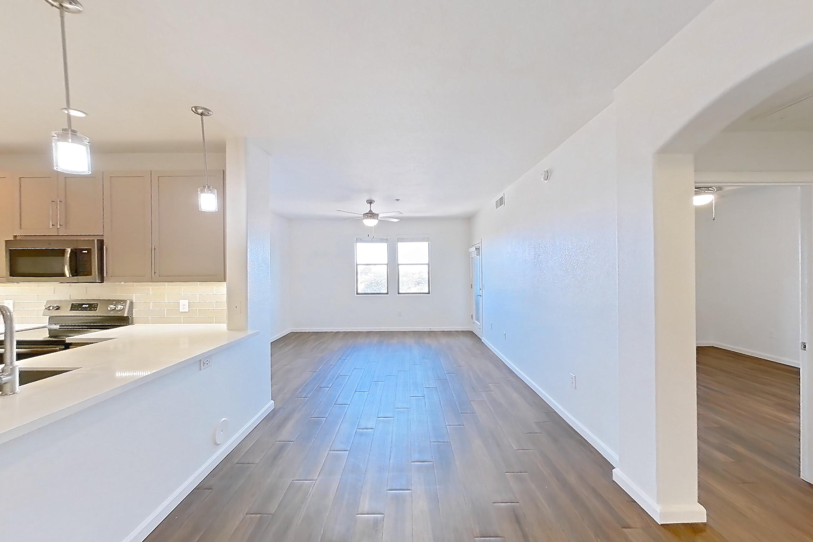 Dining room with dark wood-finish flooring, electric range, light countertops, light stone countertops, oven/range, refrigerator, and stainless steel appliances, Apartment 3091 at Cortland South Mountain