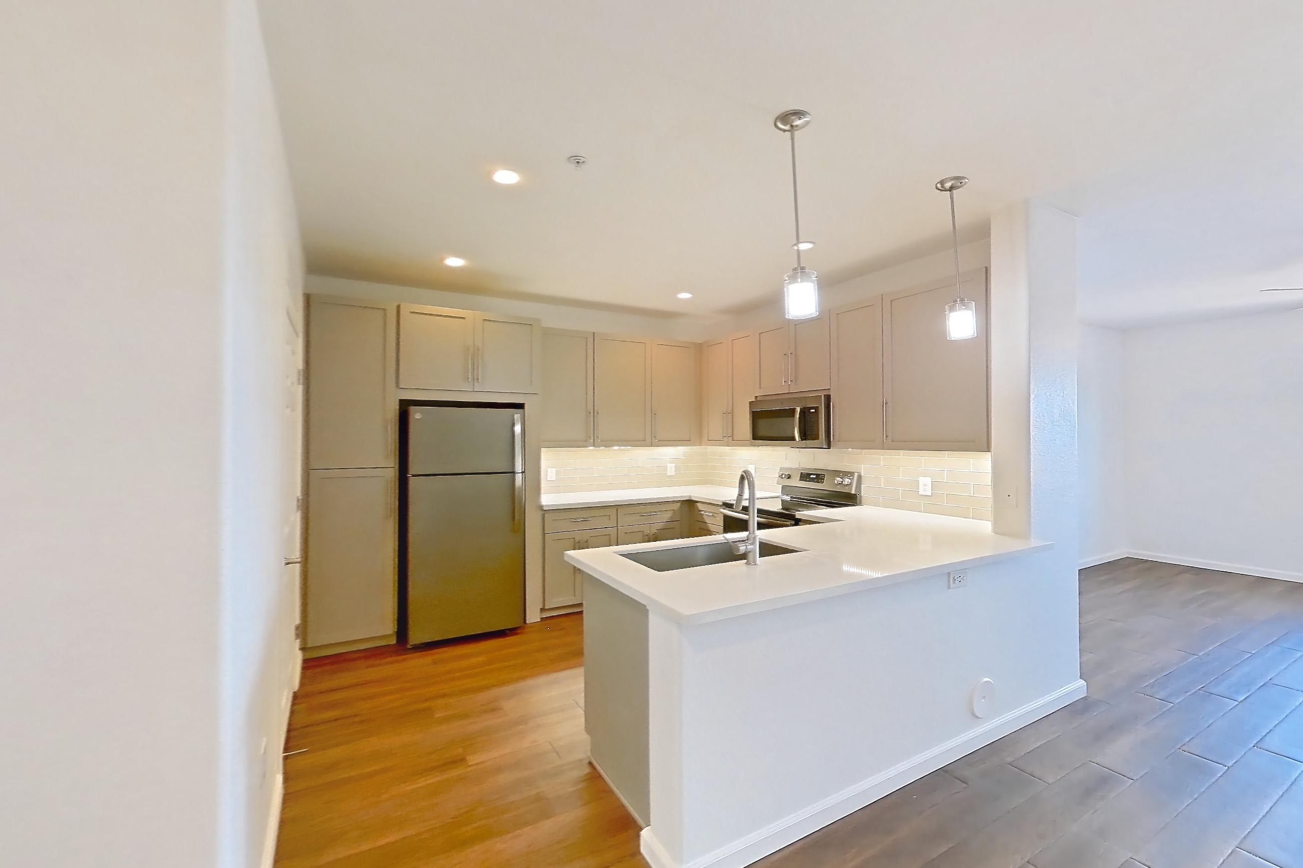 Dining room with dark wood-finish flooring, electric range, light countertops, light stone countertops, oven/range, refrigerator, and stainless steel appliances, Apartment 3091 at Cortland South Mountain