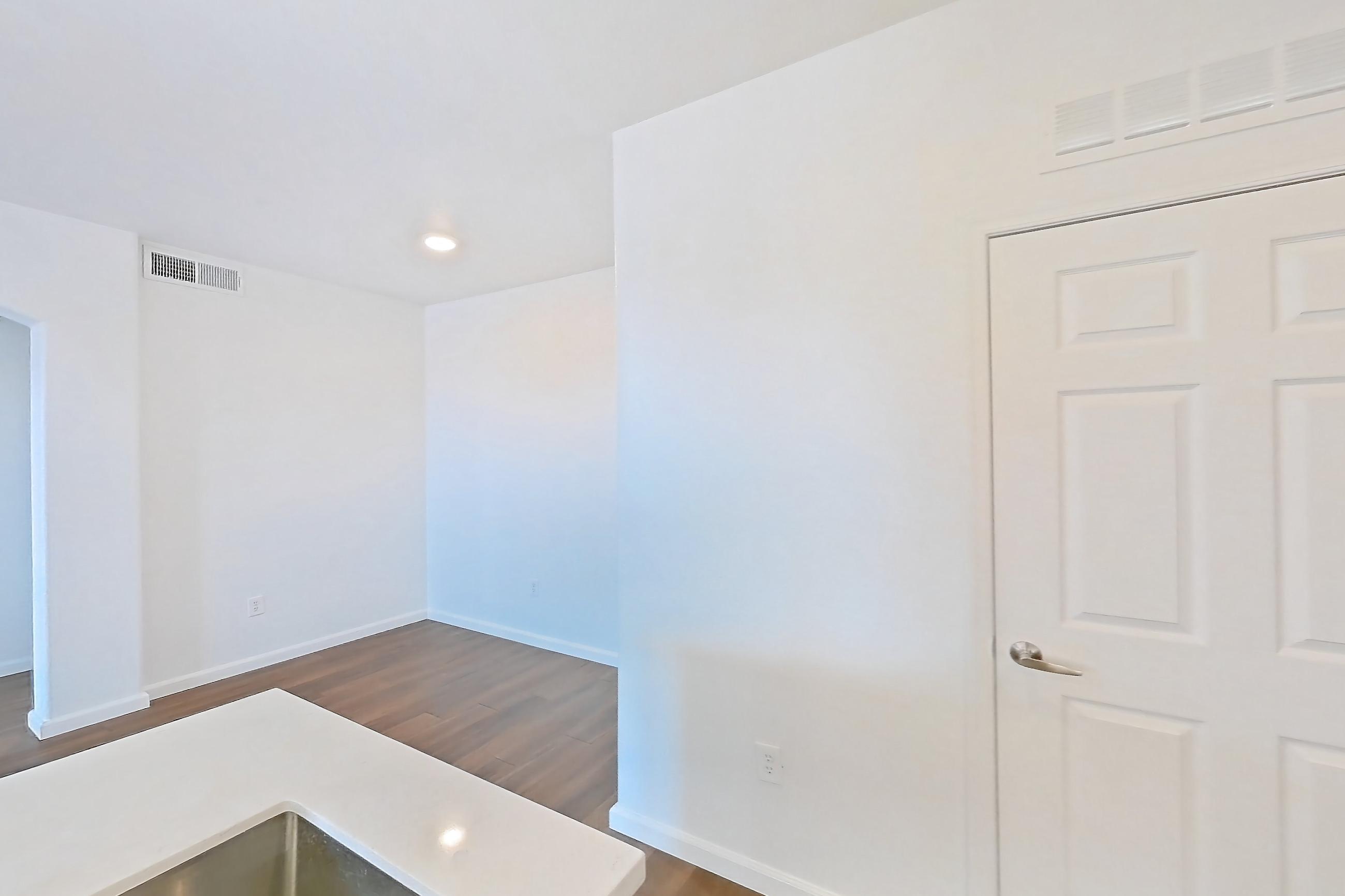 Kitchen with dark wood-finish flooring, dishwasher, electric range, light countertops, light stone countertops, light wood-finish flooring, microwave, oven/range, and stainless steel appliances, Apartment 3091 at Cortland South Mountain