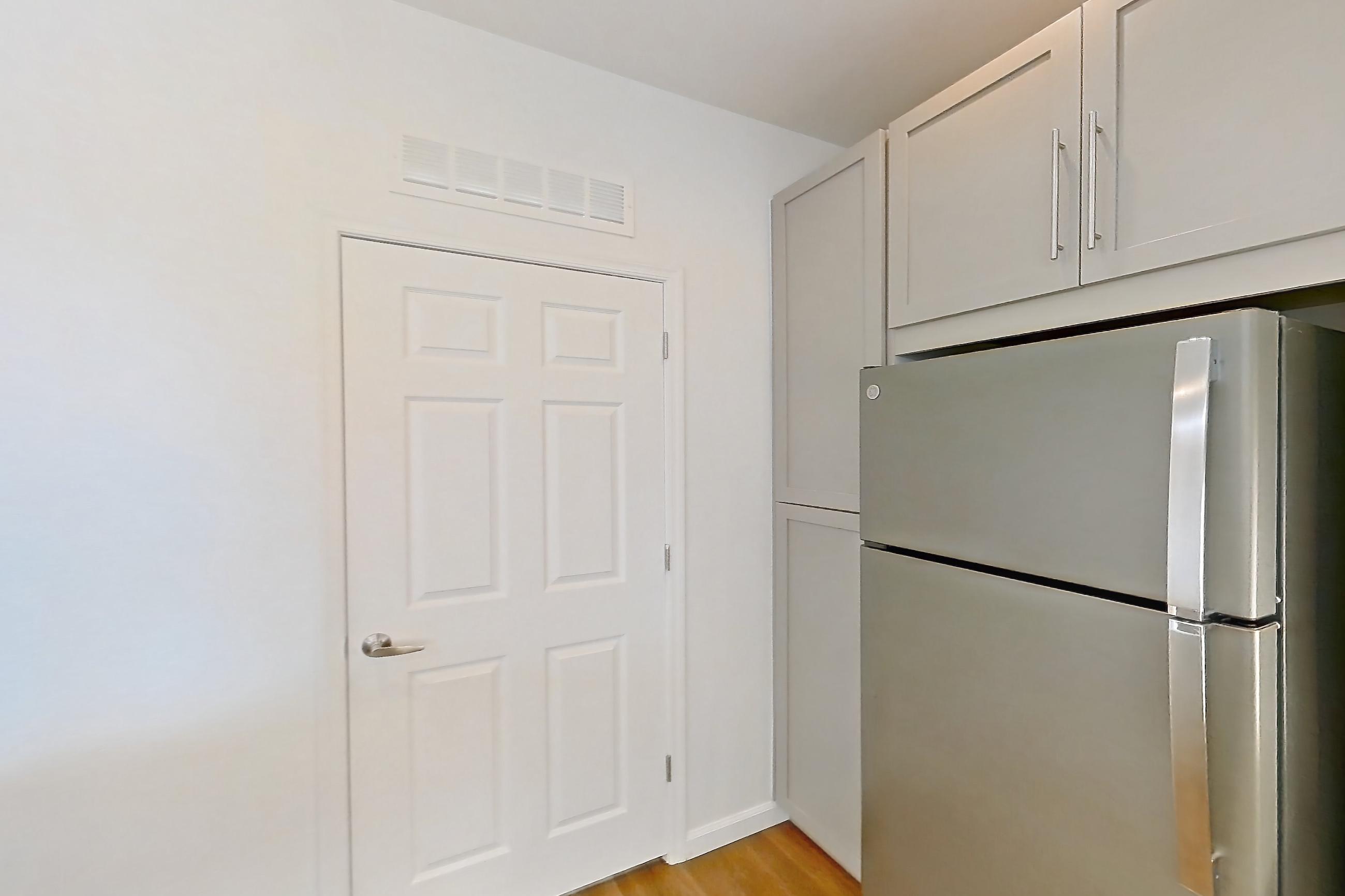 Kitchen with dark wood-finish flooring, dishwasher, electric range, light countertops, light stone countertops, light wood-finish flooring, microwave, oven/range, and stainless steel appliances, Apartment 3091 at Cortland South Mountain
