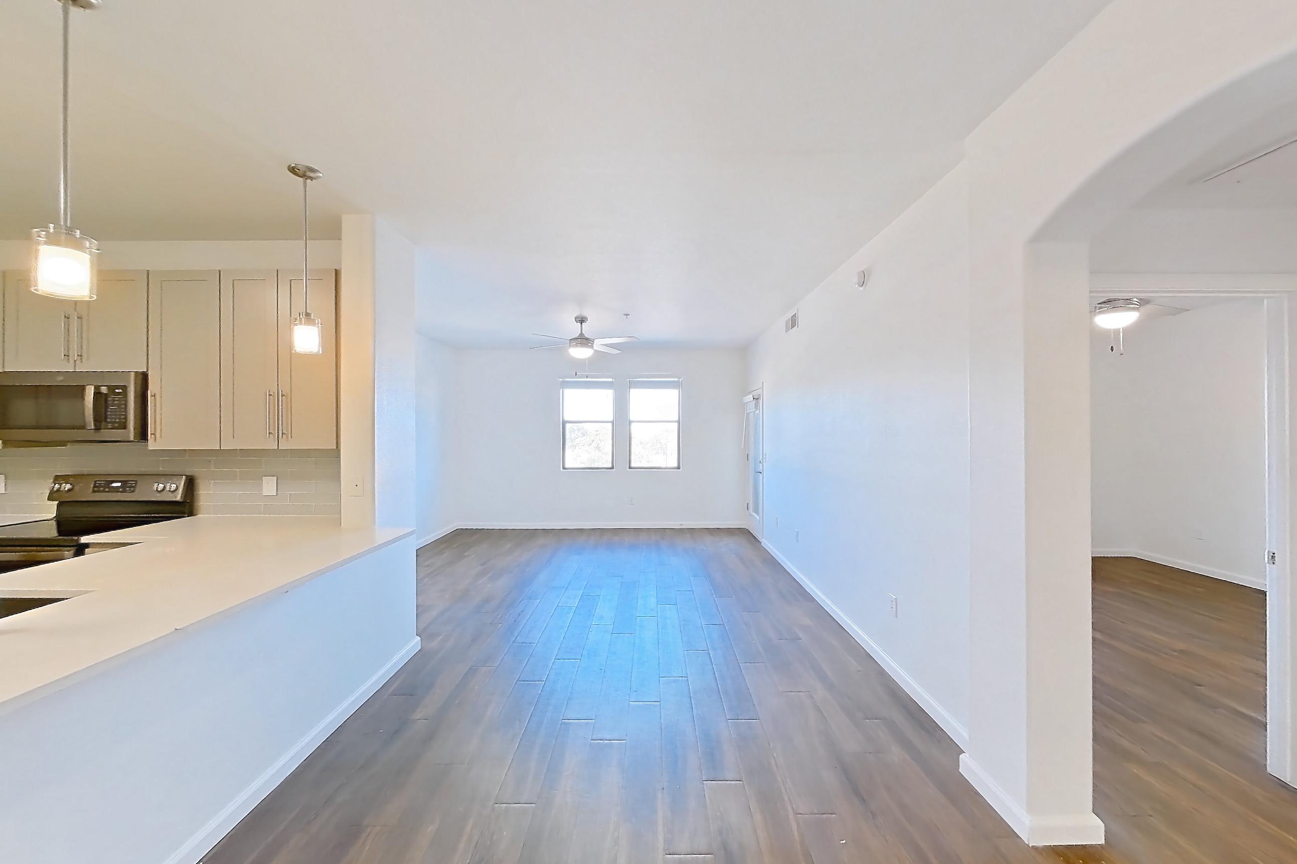 Dining room with black appliances, dark wood-finish flooring, light countertops, oven/range, refrigerator, and stainless steel appliances, Apartment 3101 at Cortland South Mountain