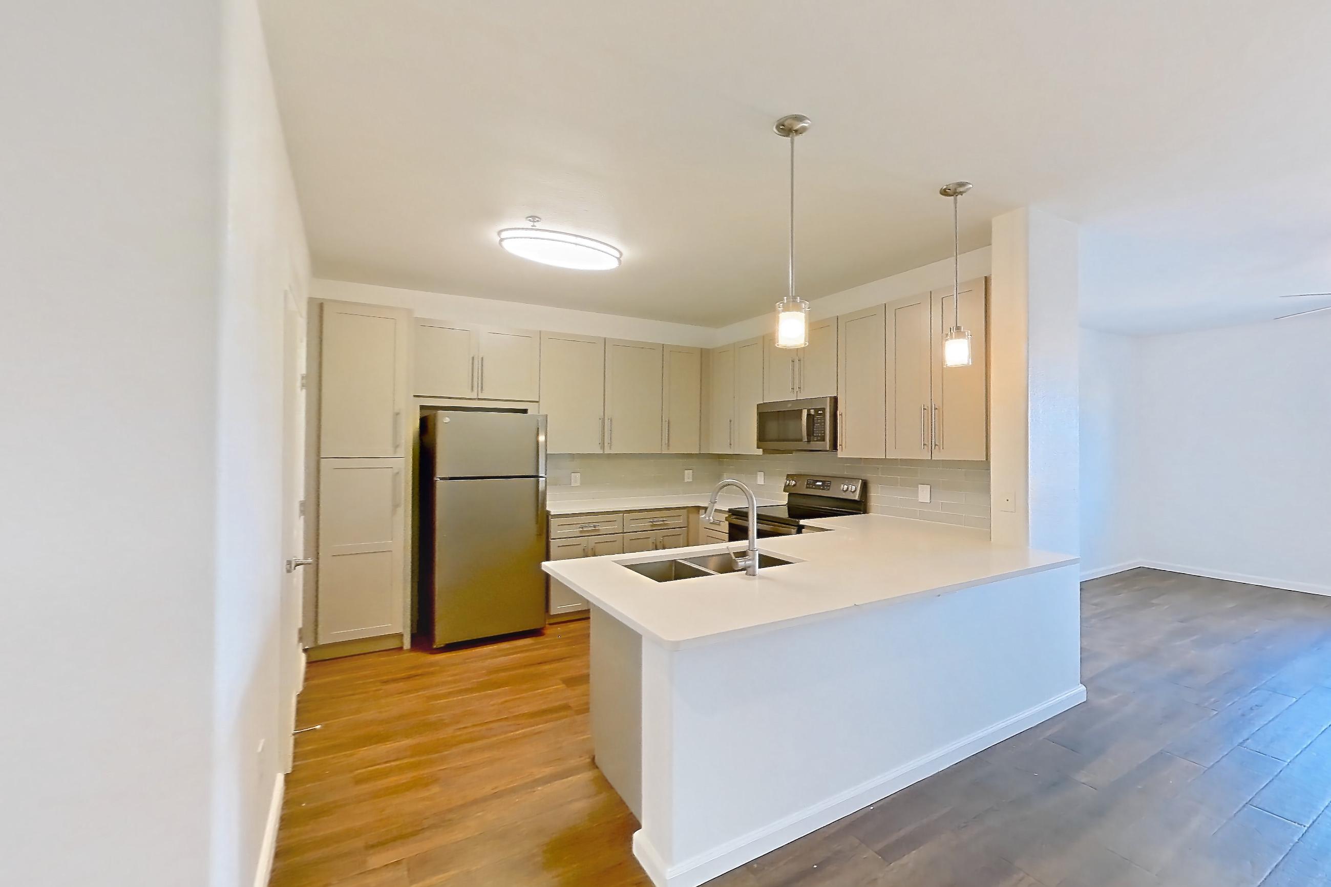 Dining room with black appliances, dark wood-finish flooring, light countertops, oven/range, refrigerator, and stainless steel appliances, Apartment 3101 at Cortland South Mountain