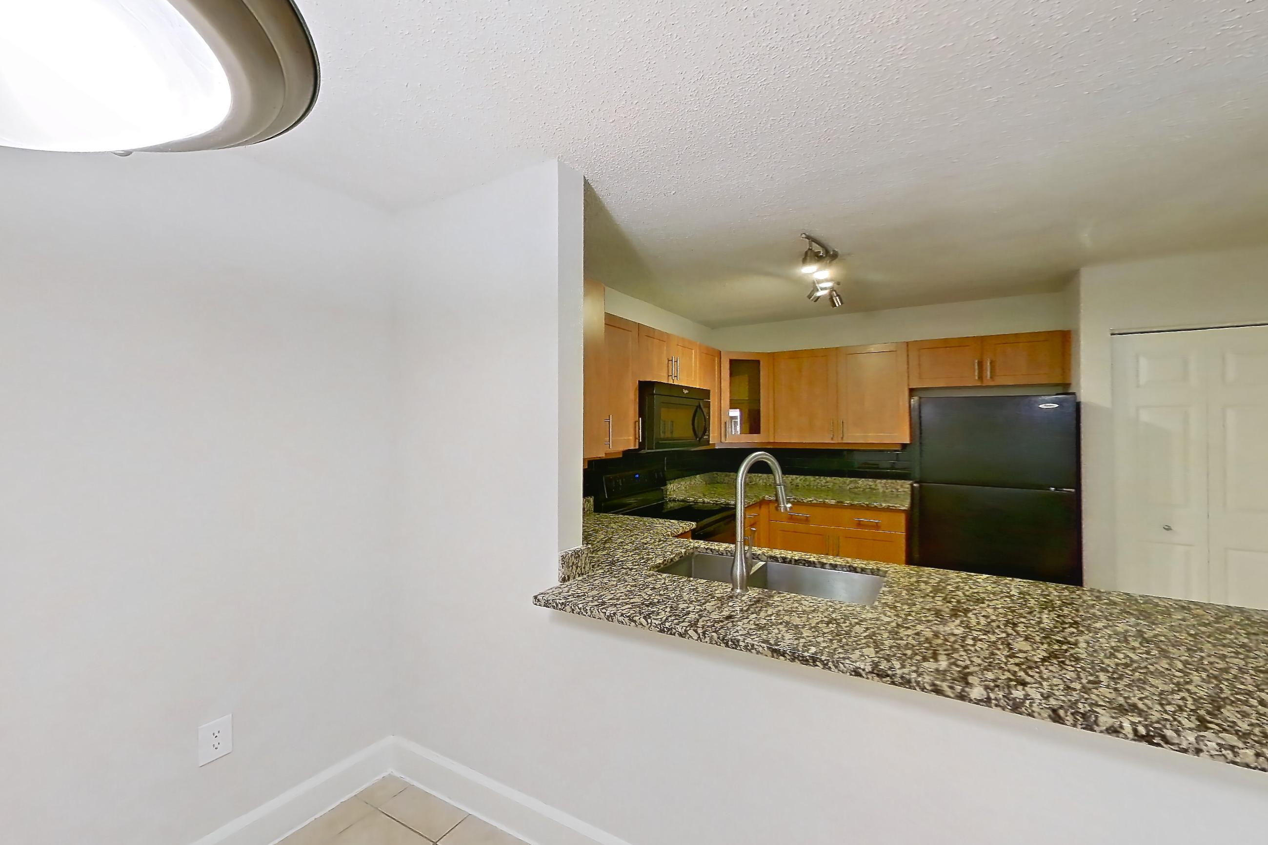 Dining room with black appliances, dark stone countertops, electric range, light countertops, light tile flooring, oven/range, and refrigerator, Apartment 455465 at Cortland Bayport