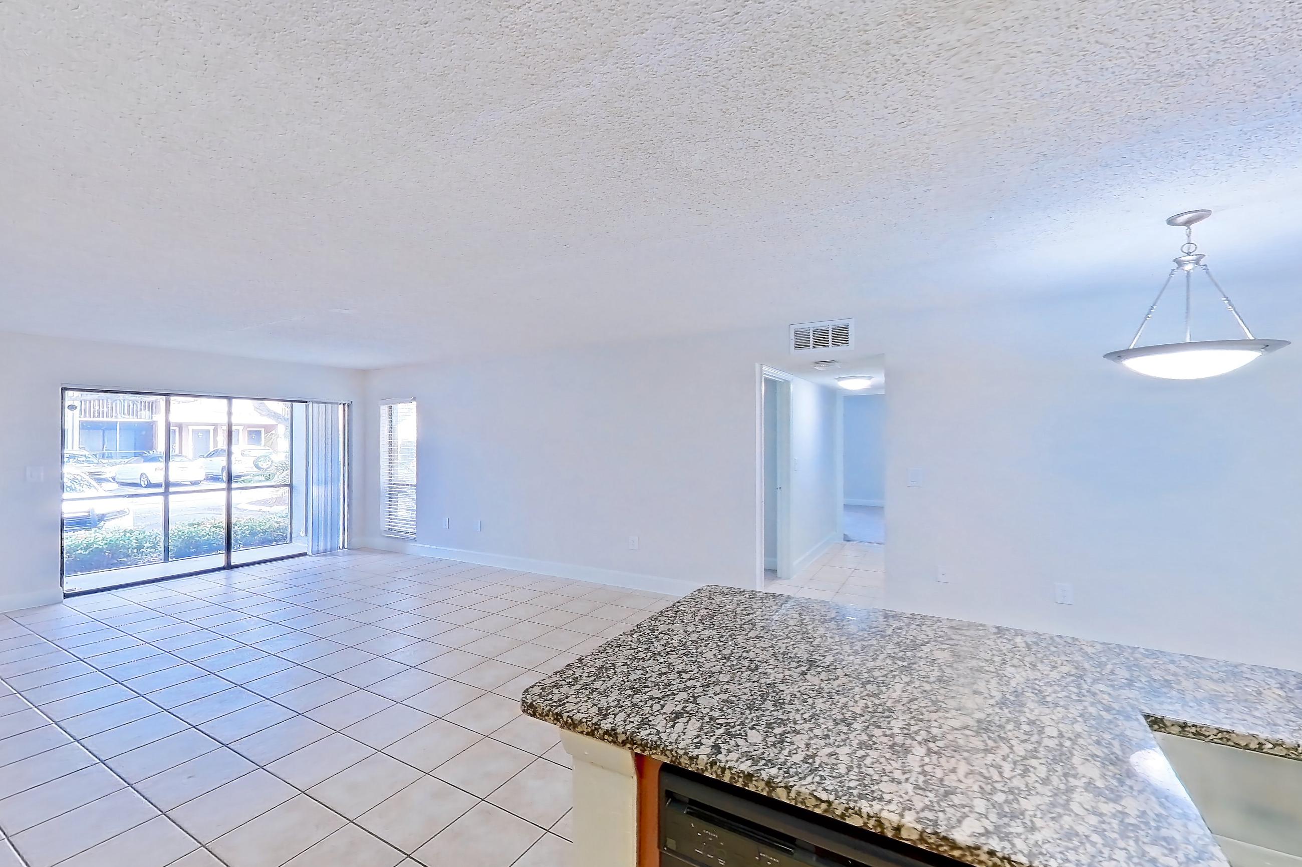 Kitchen with black appliances, dishwasher, electric range, light stone countertops, light tile flooring, microwave, oven/range, and refrigerator, Apartment 455465 at Cortland Bayport