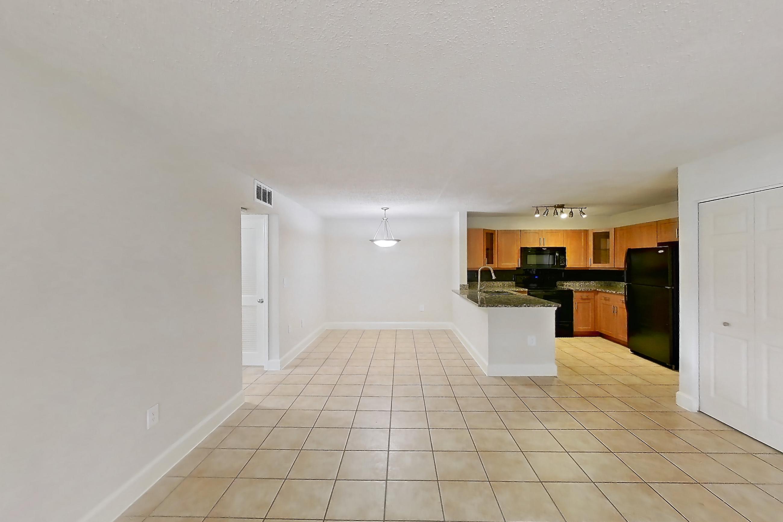 Living space with black appliances, dark stone countertops, light tile flooring, oven/range, and refrigerator, Apartment 455465 at Cortland Bayport
