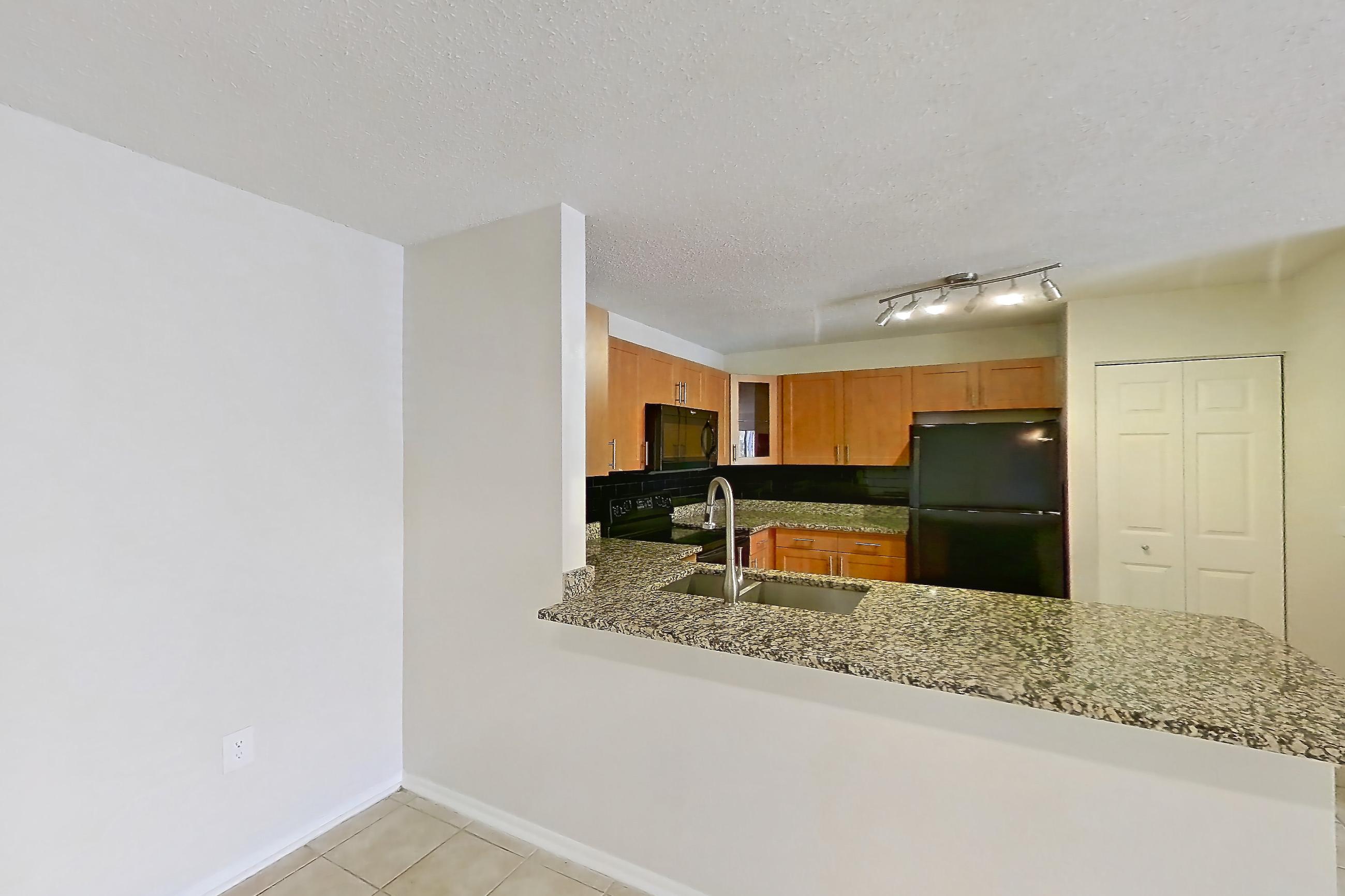 Dining room with black appliances, dark stone countertops, electric range, light countertops, light tile flooring, oven/range, and refrigerator, Apartment 465442 at Cortland Bayport