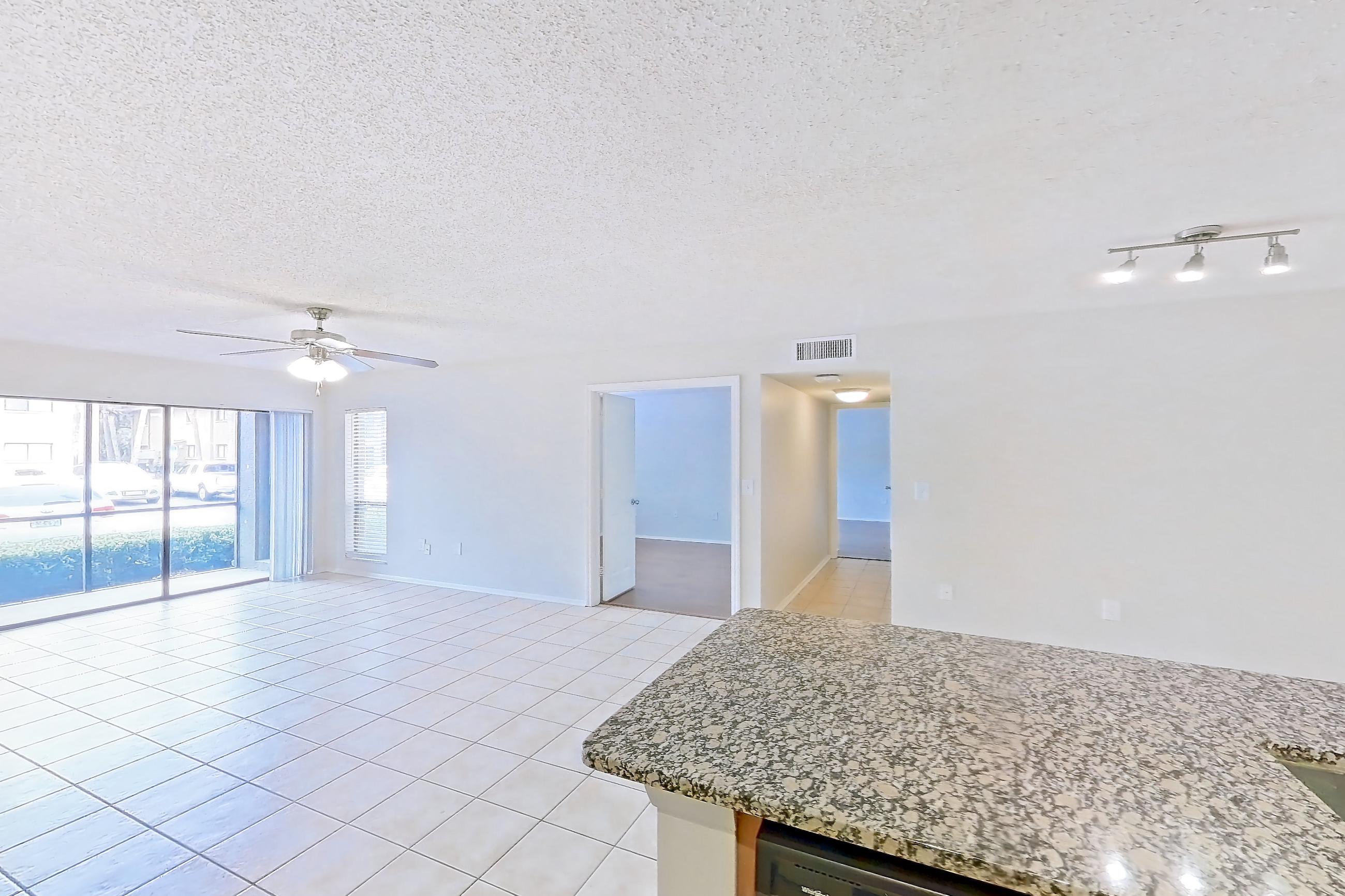 Kitchen with black appliances, dishwasher, electric range, light stone countertops, light tile flooring, microwave, oven/range, and refrigerator, Apartment 465442 at Cortland Bayport