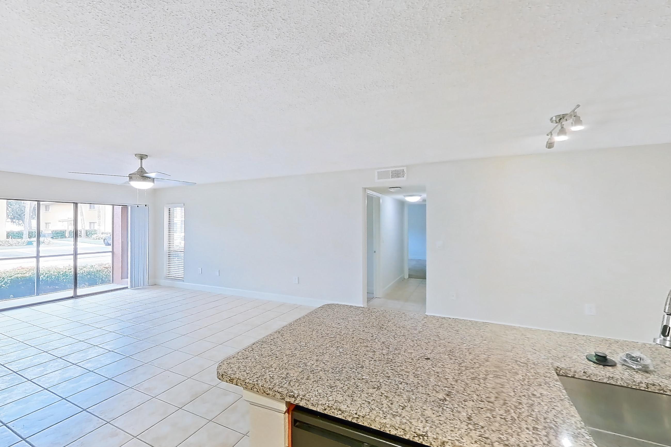 Kitchen with black appliances, dishwasher, electric range, light stone countertops, light tile flooring, microwave, oven/range, refrigerator, and stainless steel appliances, Apartment 475441 at Cortland Bayport