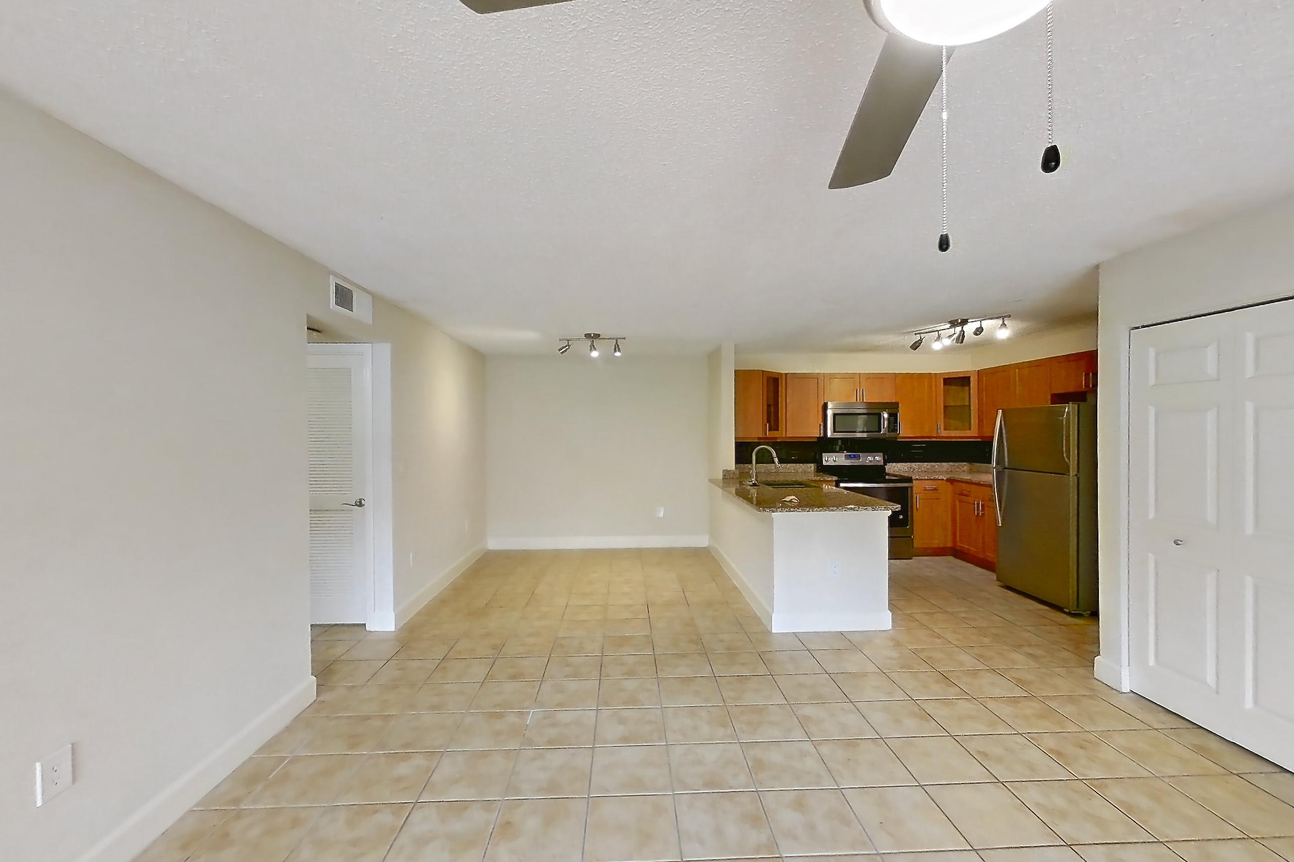 Living space with dark stone countertops, electric range, light tile flooring, oven/range, refrigerator, and stainless steel appliances, Apartment 475441 at Cortland Bayport